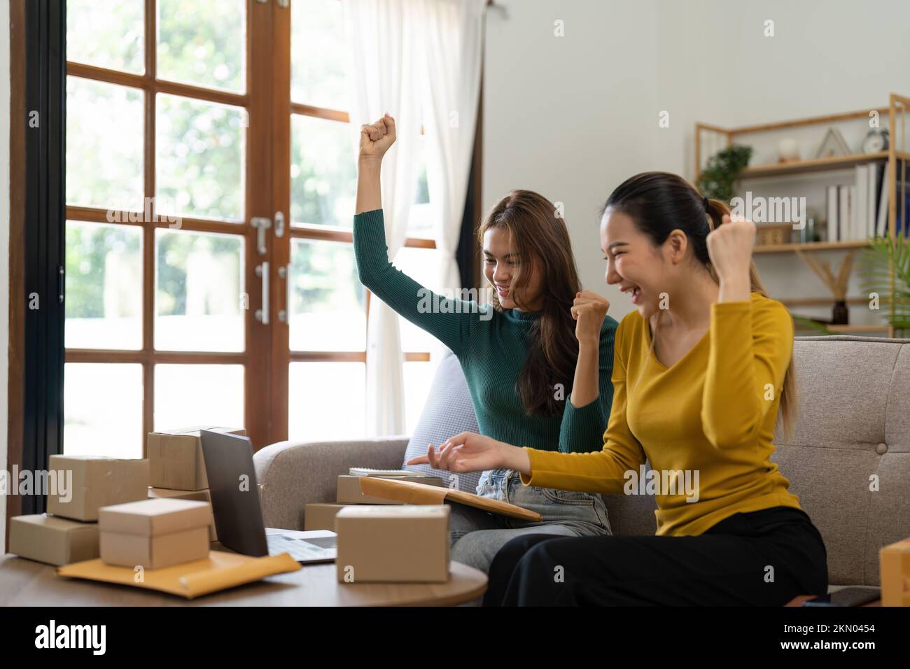 Dos jóvenes mujeres asiáticas son felices y emocionados después de una nueva orden de cliente de la PYME, comprobación comercial, marketing en línea, Emprendedor cajas de embalaje Foto de stock