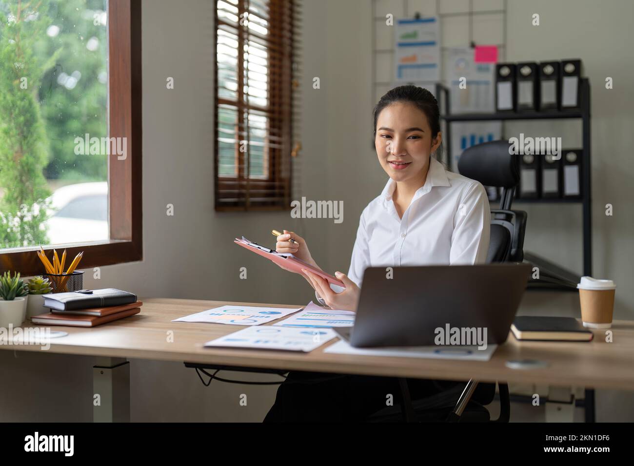 Mujer contable usando calculadora y computadora portátil en concepto de oficina, finanzas y contabilidad Foto de stock