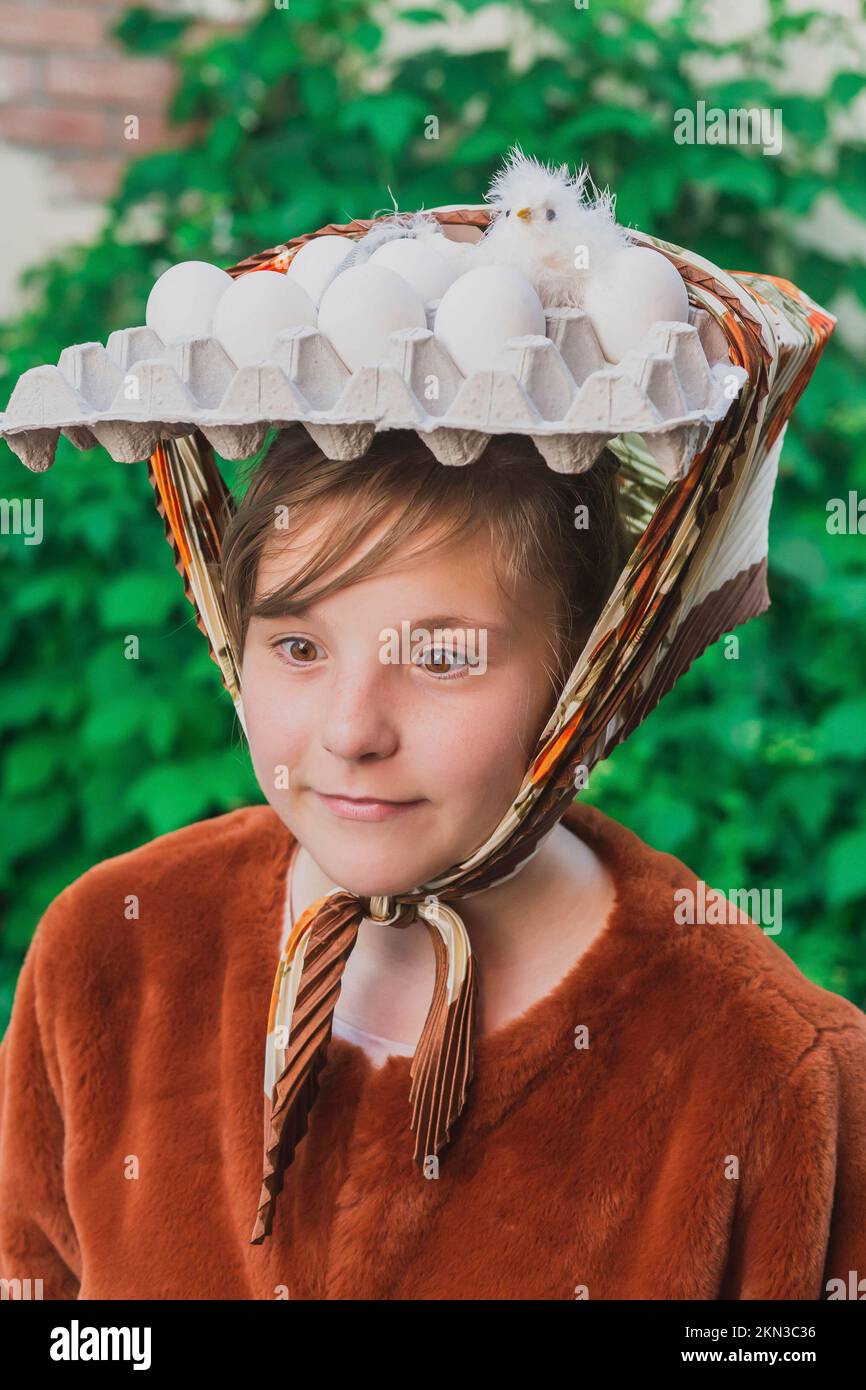 Adolescente con huevos y polluelo en la cabeza Foto de stock