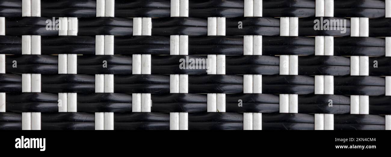 Textura de fondo de tiras tejidas de plástico blanco y negro en formato panorámico Foto de stock