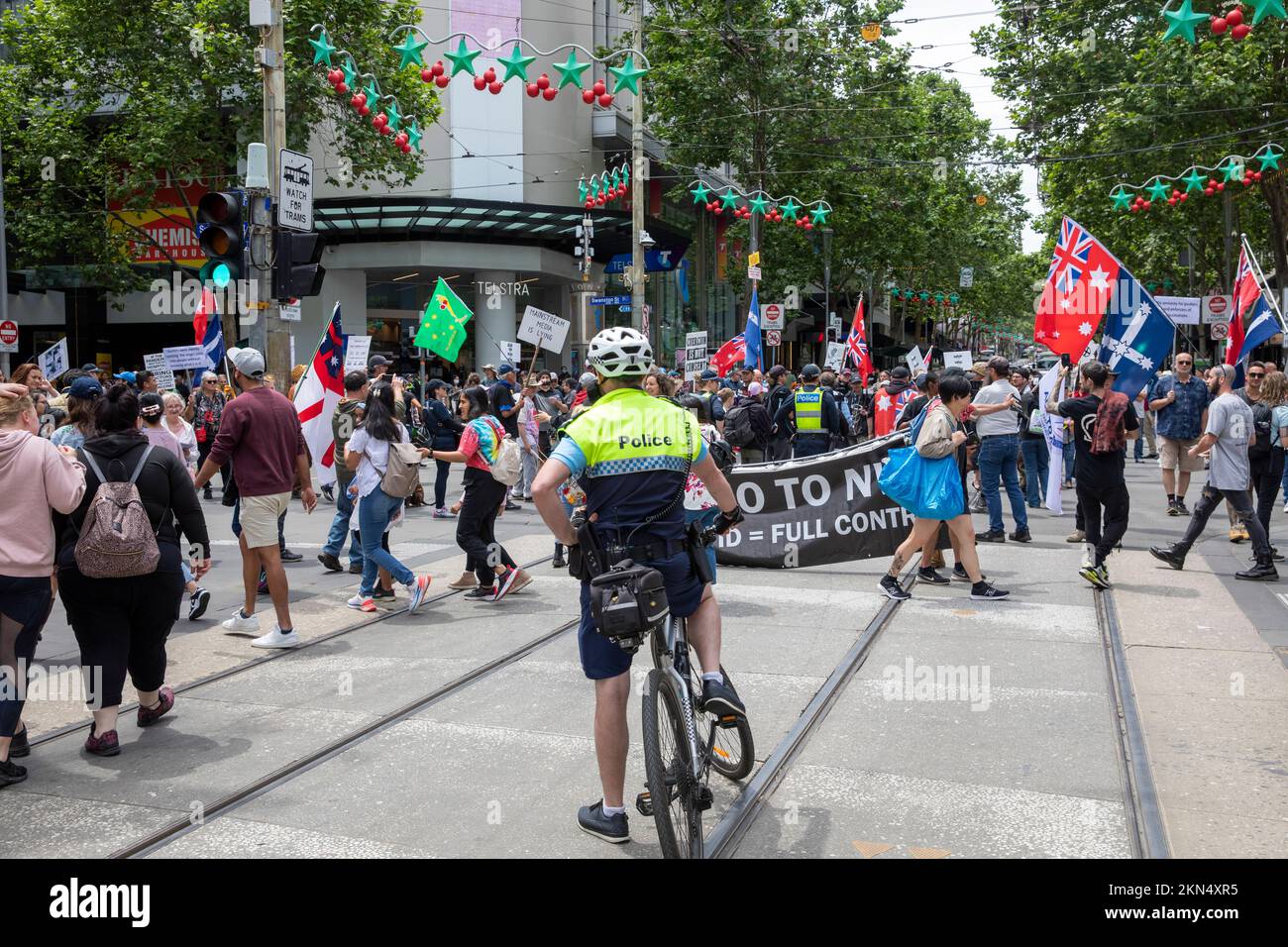 Oficial de policía de Melbourne en una bicicleta parte de la operación policial vigilando la protesta contra las vacunas en el centro de la ciudad de Melbourne, Victoria, Australia Foto de stock