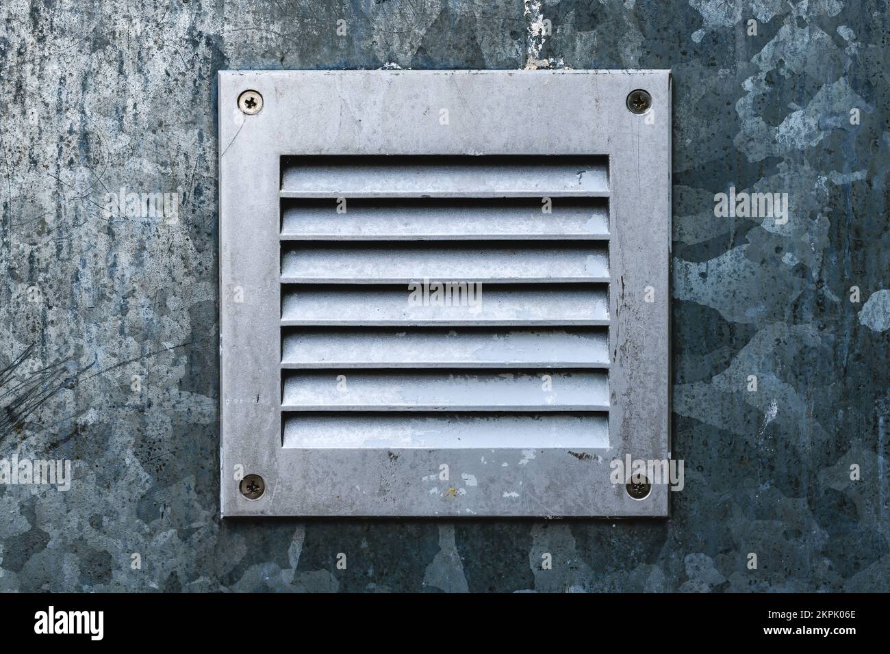Pequeña rejilla de ventilación chapada en metal de zinc en la pared como fondo industrial Foto de stock