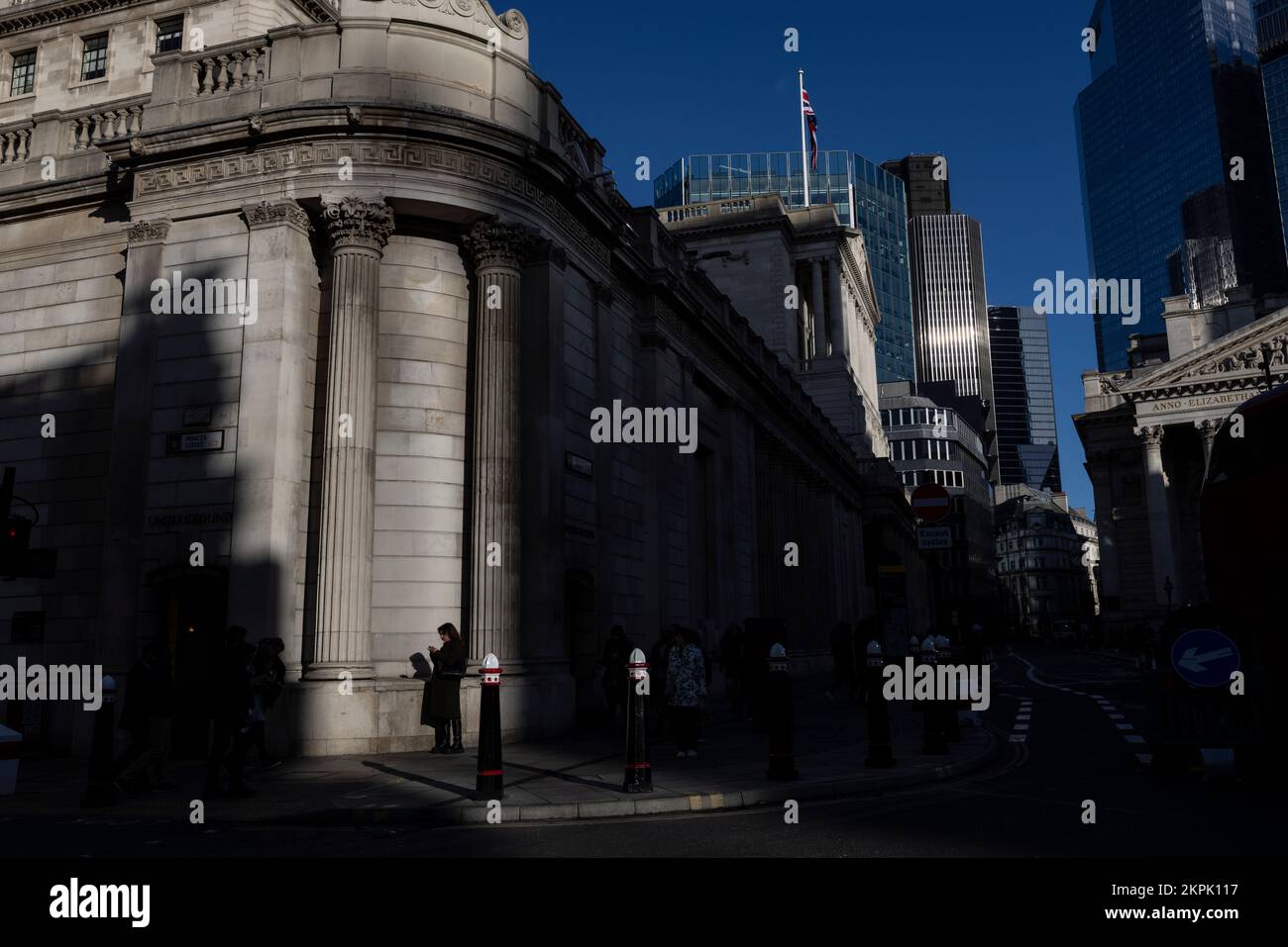 Los trabajadores de la ciudad en la tarde se desvanecen la luz fuera del Banco de Inglaterra, esquina de la Estación Bancaria mientras la ciudad continúa a través de la penumbra financiera, Reino Unido Foto de stock