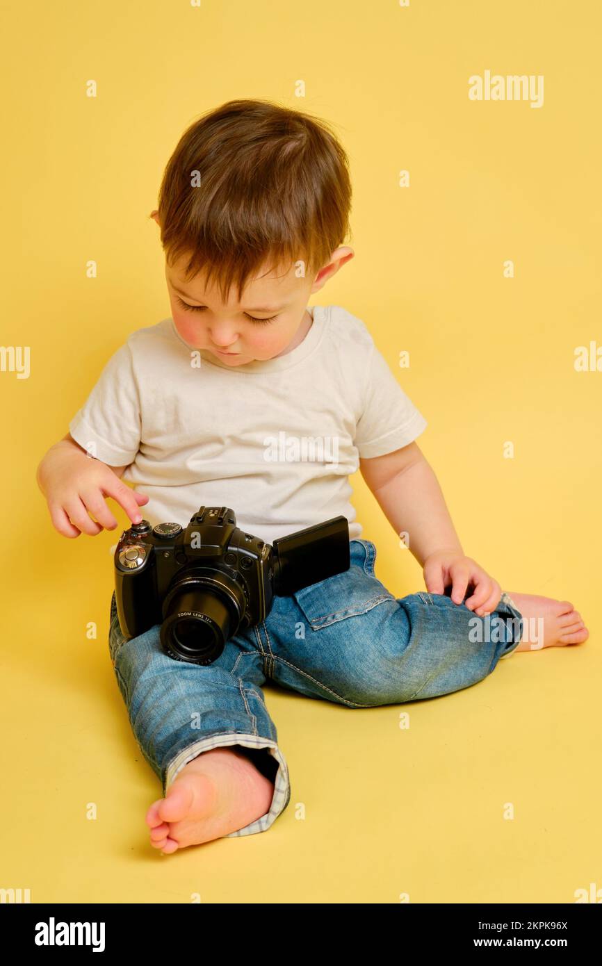 Niño con cámara. niña fotografiando en el fondo del estudio