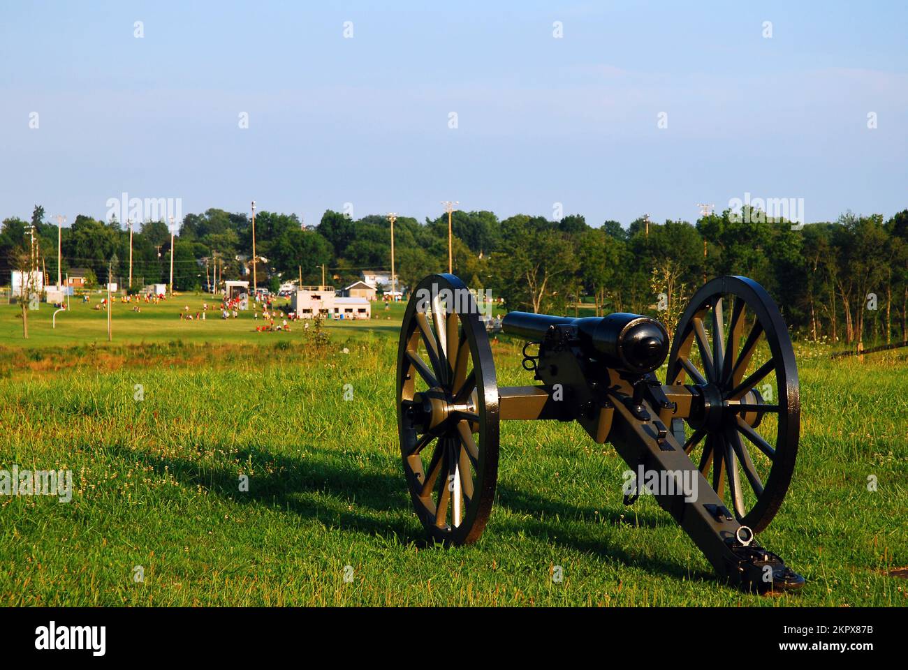 Un cañón de la Guerra Civil Americana parece apuntar a un campo atlético en Gettysburg, Pensilvania Foto de stock
