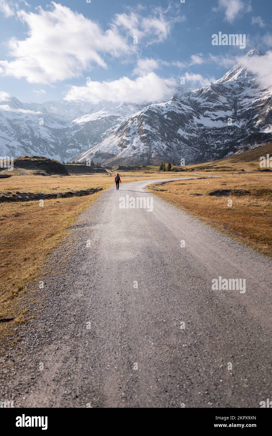 Vista trasera de una mujer caminando por un sendero alpino hacia las montañas, Gastein, Salzburgo, Austria Foto de stock