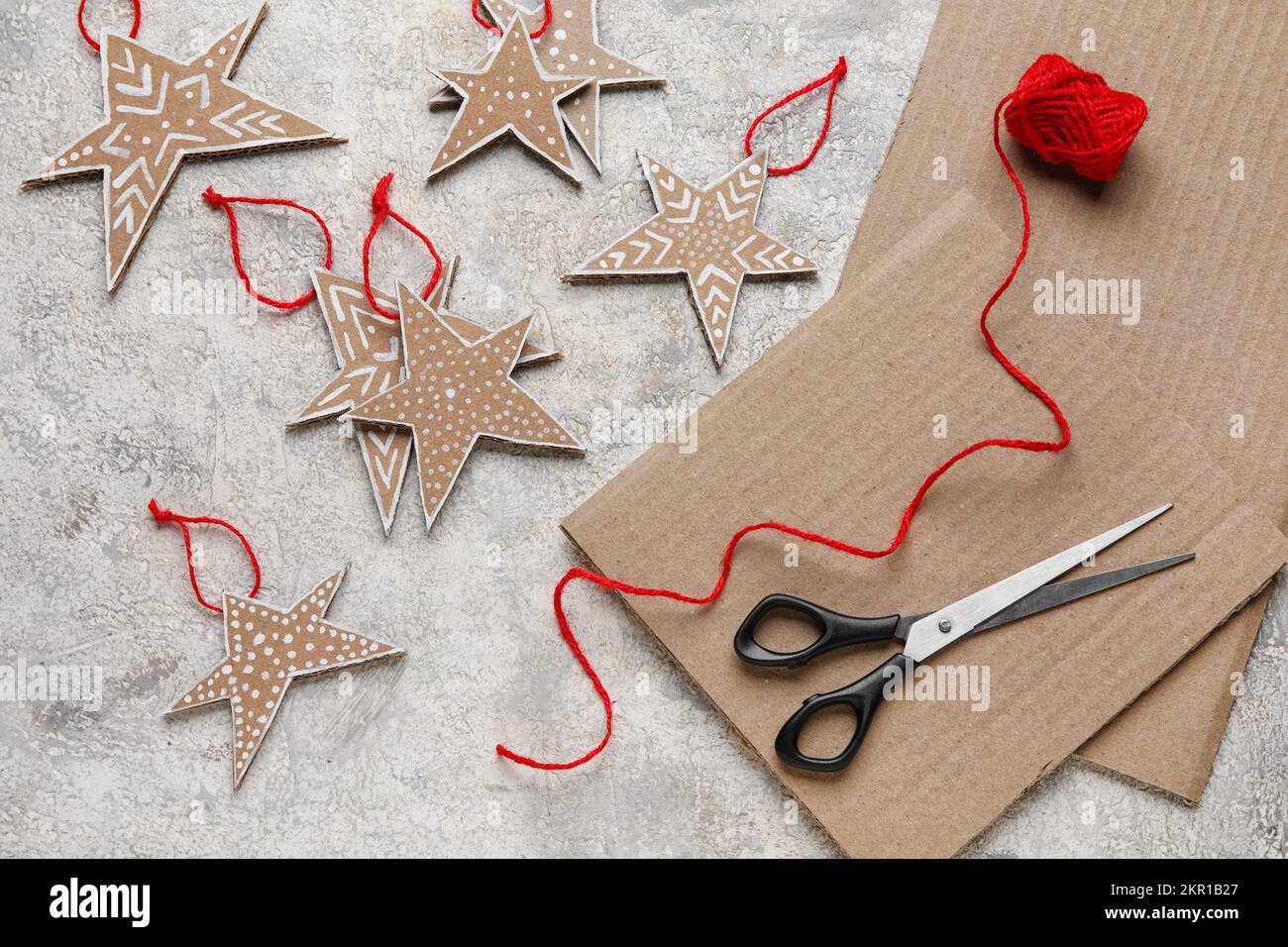 Estrellas de cartón de Navidad con hilos y tijeras sobre fondo grunge  Fotografía de stock - Alamy