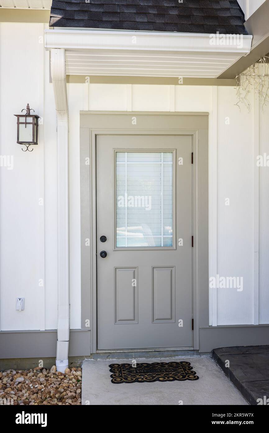 Una puerta trasera marrón de una casa de color crema de nueva construcción  con un lado resistente de tablas cerca de la entrada del patio Fotografía  de stock - Alamy