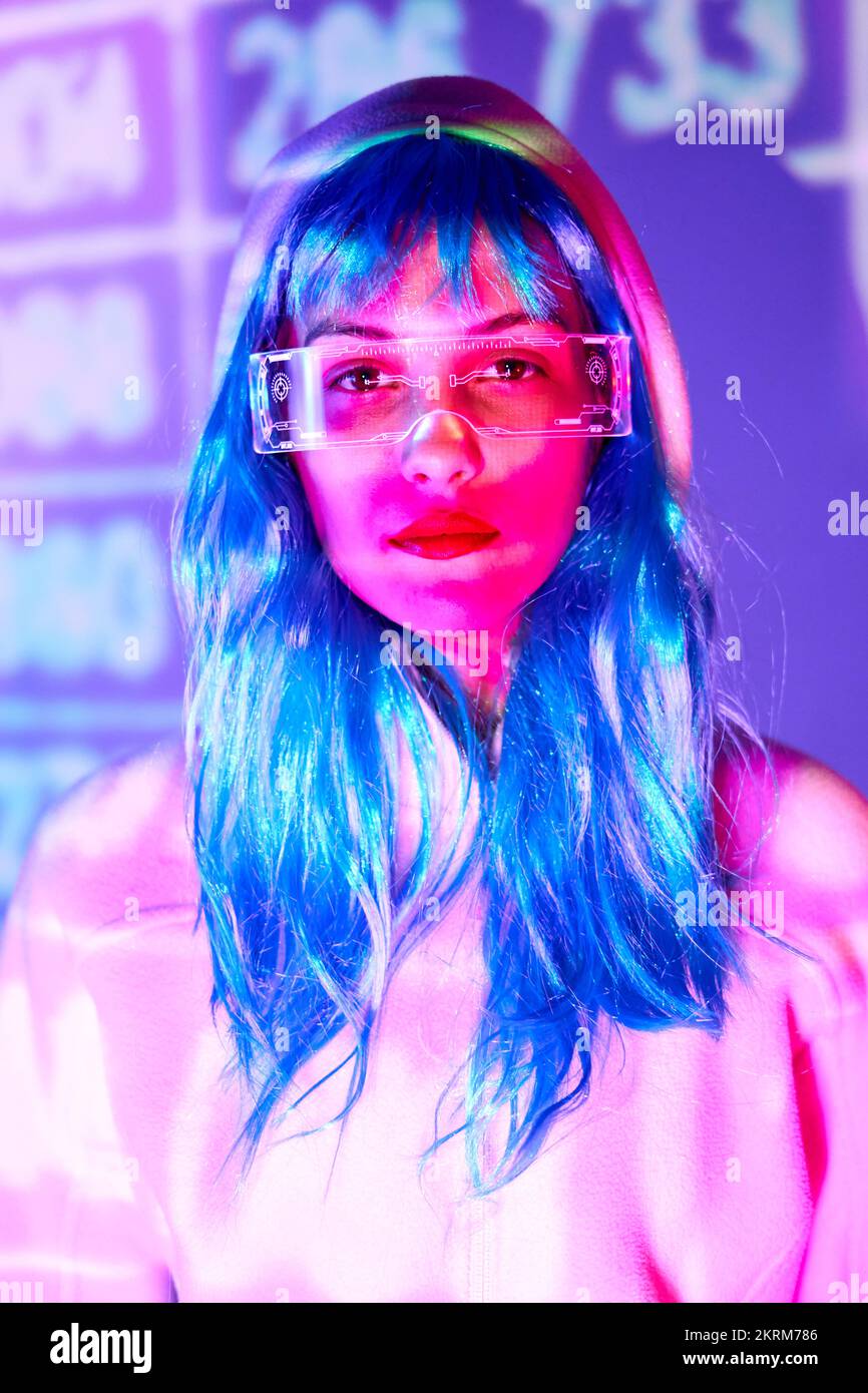 Joven peluca con gafas de realidad aumentada inteligentes con pantalla  virtual que muestra iconos mientras está en el estudio con luces violeta de  neón brillantes Fotografía de stock - Alamy