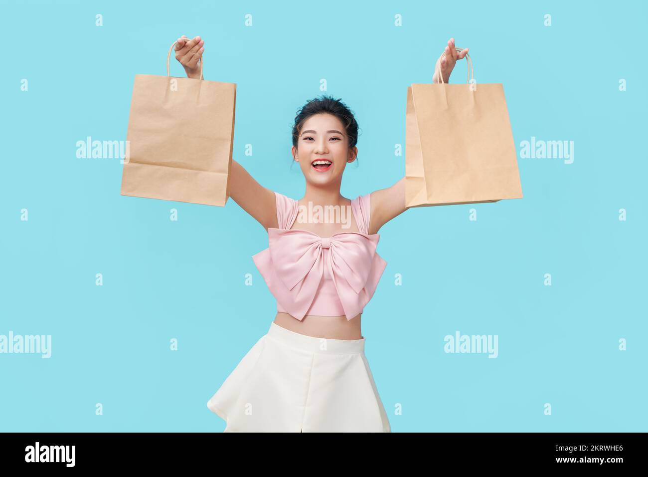 felices compras mujeres jóvenes mostrar bolsas - aisladas sobre fondo azul, Foto de stock