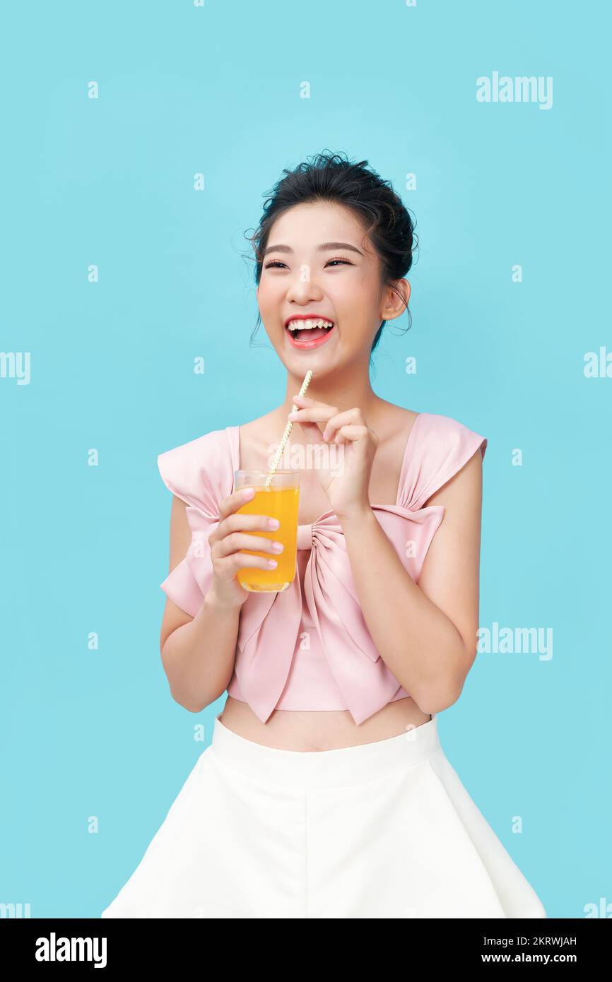 La mujer que bebe jugo de naranja Foto de stock