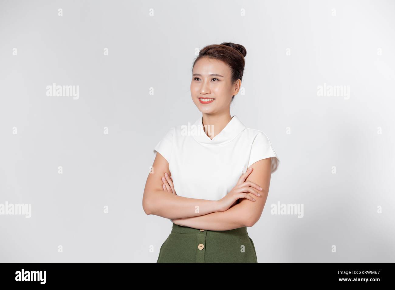 Chica asiática cara feliz sonriendo con el brazo de cruz, aislado sobre fondo blanco. Foto de stock