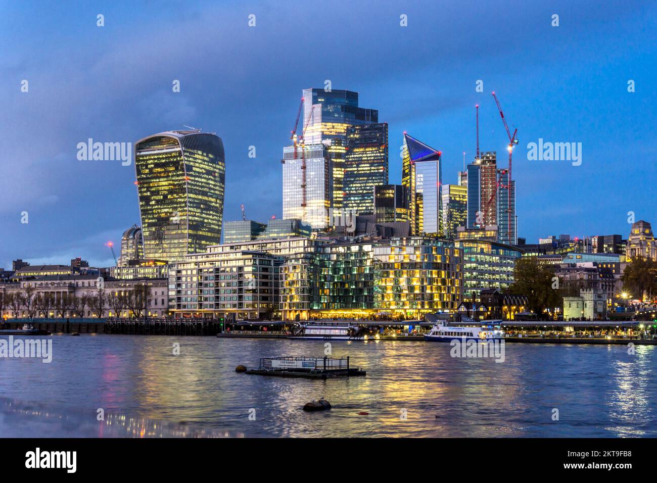 El denso desarrollo comercial del horizonte de la Ciudad de Londres visto a través del río Támesis al atardecer. Foto de stock