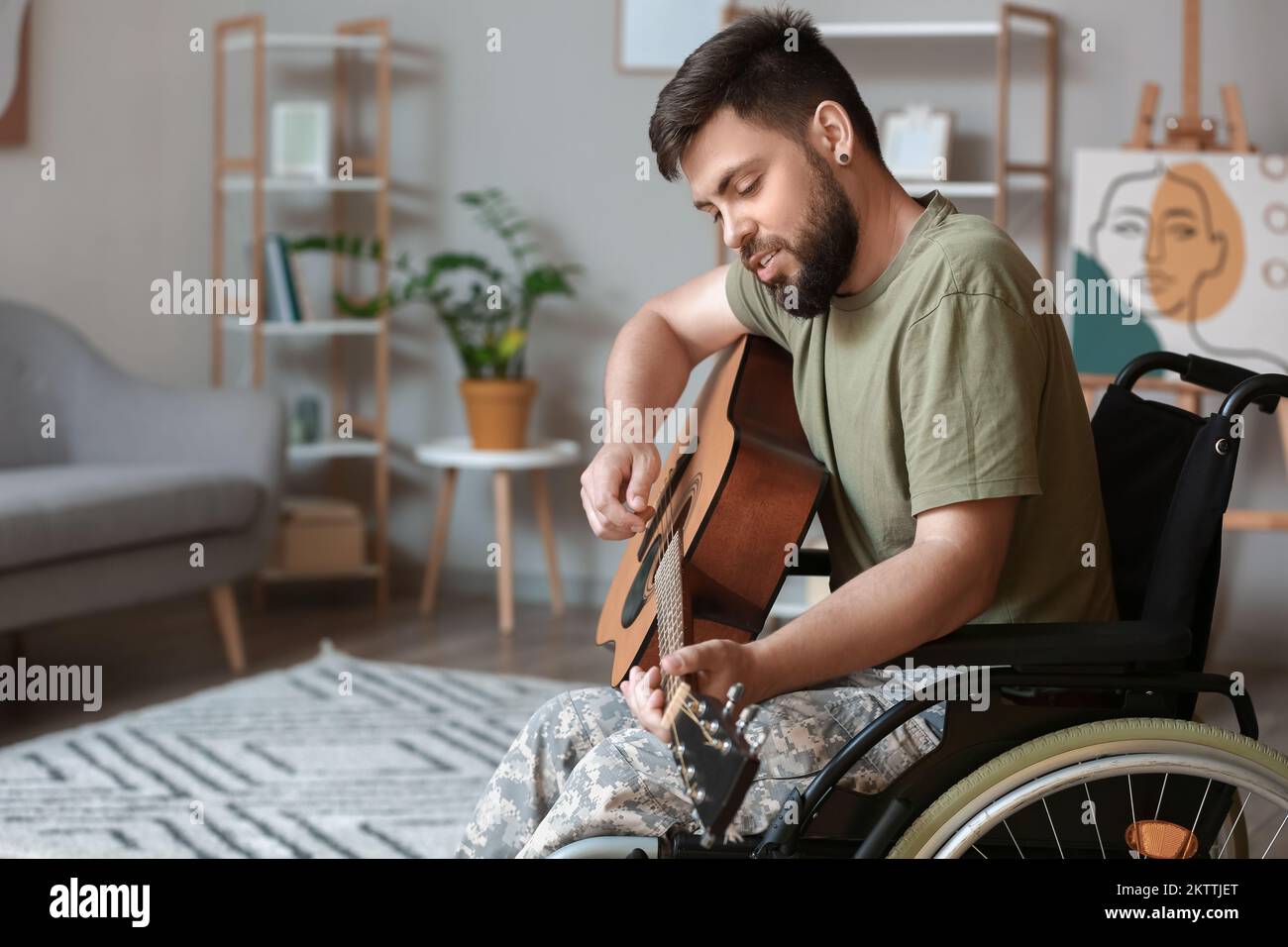Joven soldado en silla de ruedas tocando la guitarra en casa, primer plano  Fotografía de stock - Alamy