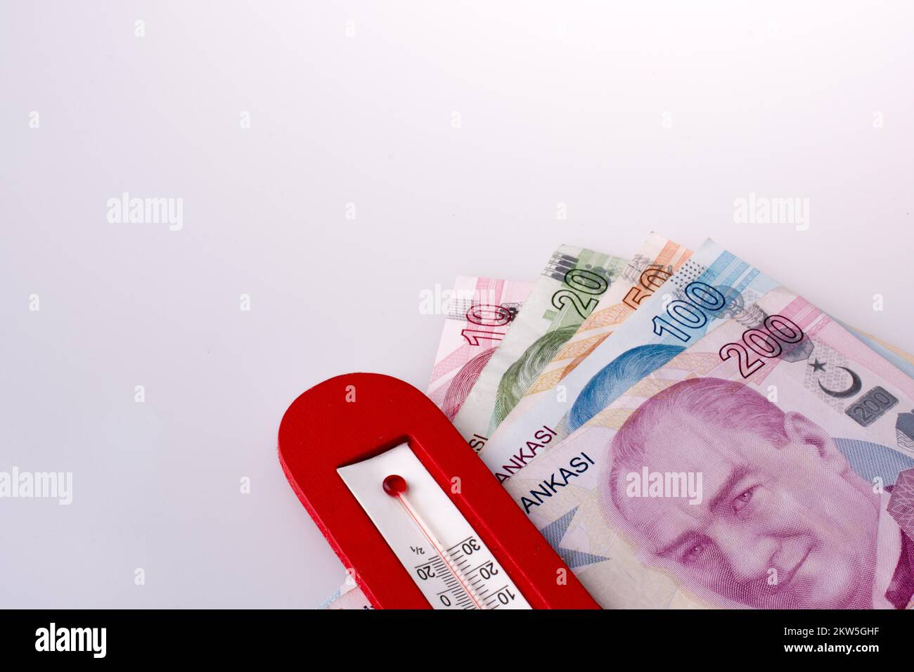 Lira turca billetes al lado de una temperatura de color rojo sobre fondo blanco. Foto de stock