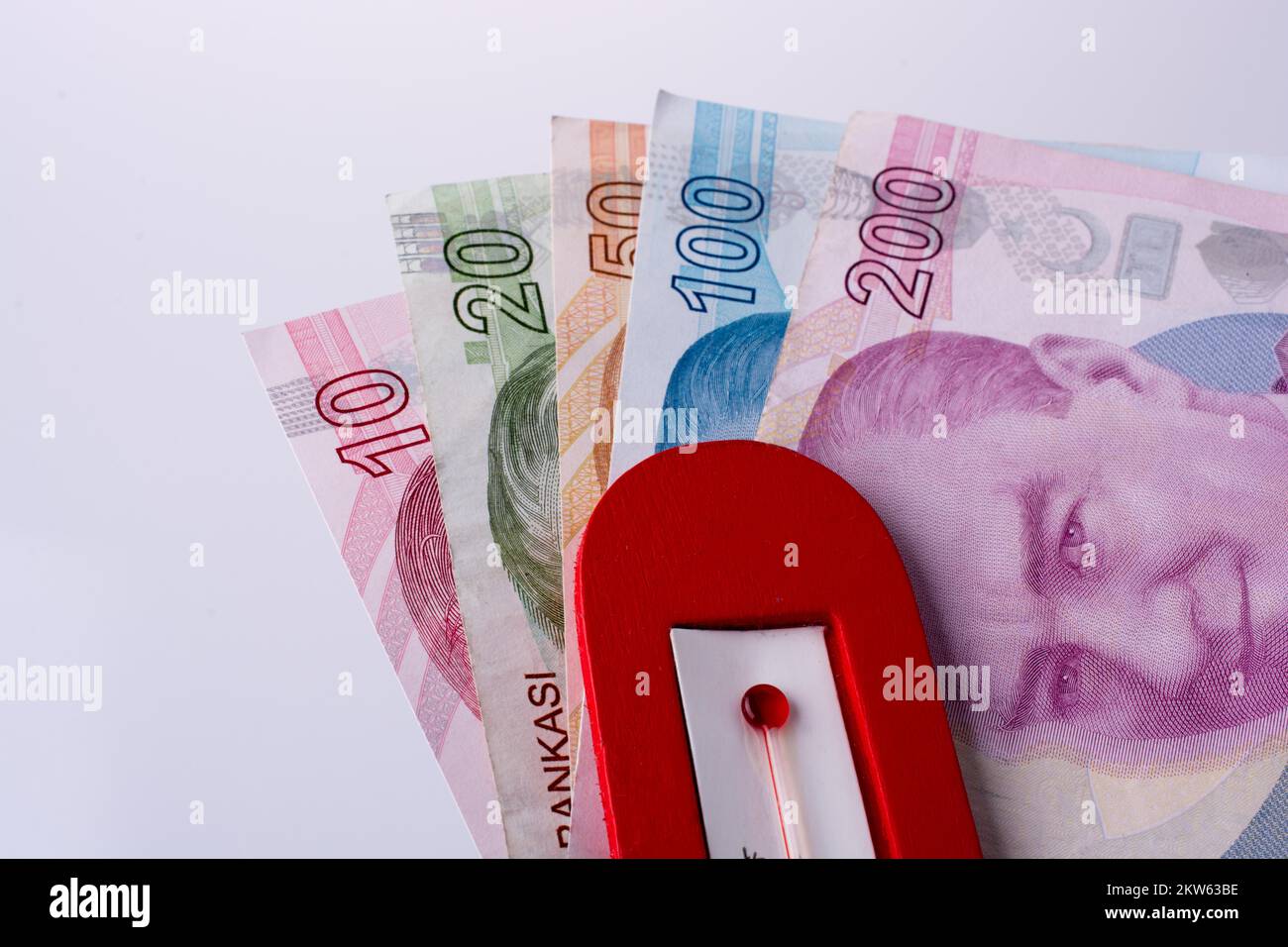 Lira turca billetes al lado de una temperatura de color rojo sobre fondo blanco. Foto de stock