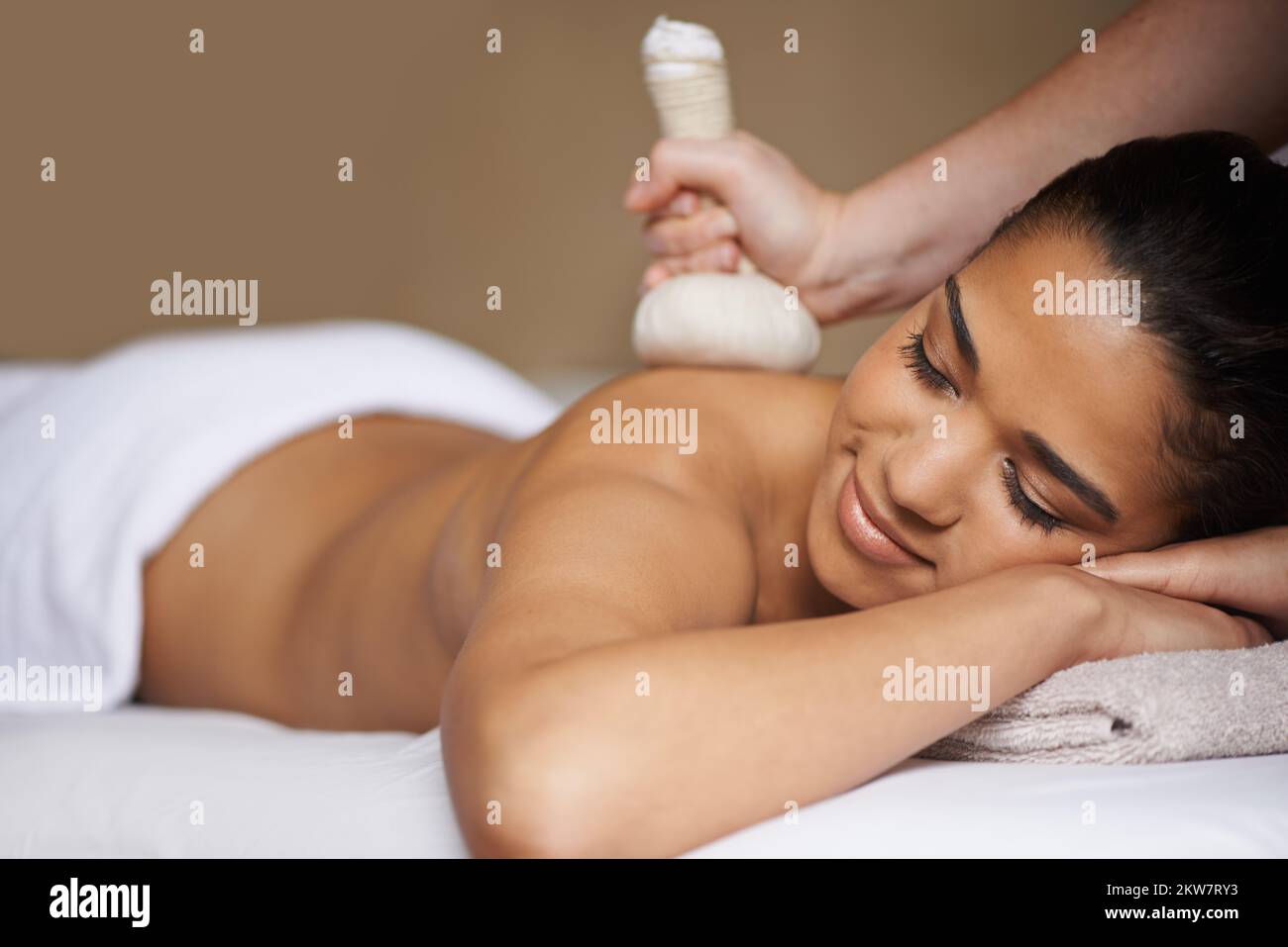 Salir de toda la ansiedad. una joven atractiva que disfruta de un masaje en el spa. Foto de stock