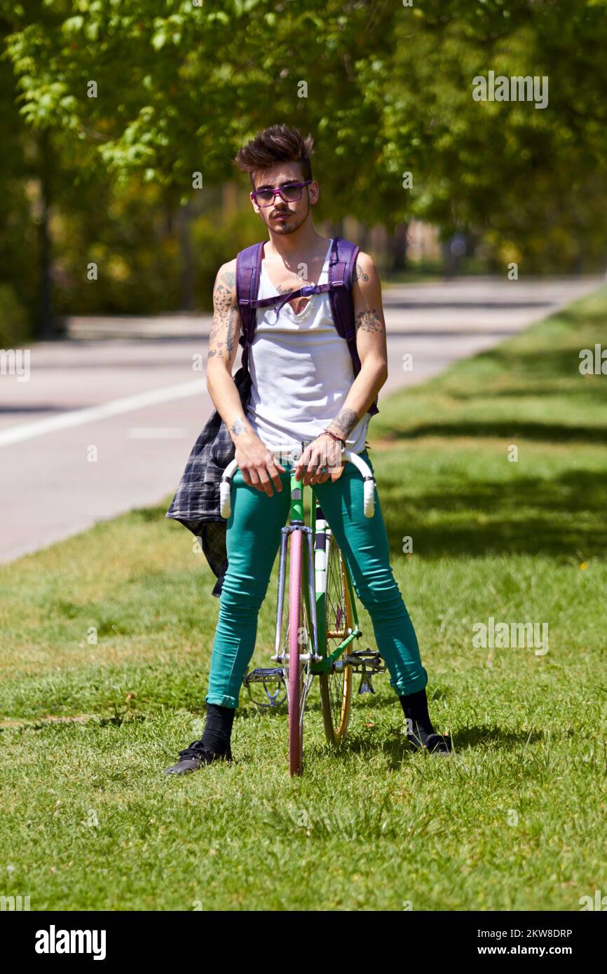 Estilin urbano. Un joven guapo montando su bicicleta al aire libre. Foto de stock