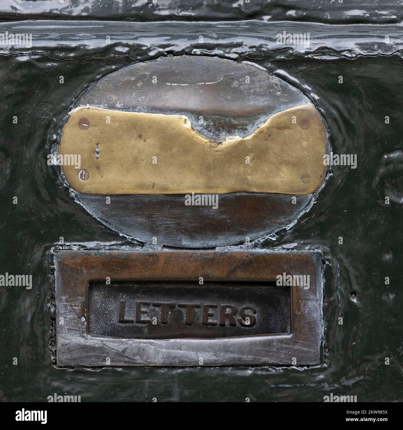 LONDRES, Reino Unido - 16 DE NOVIEMBRE de 2022: Primer plano de la antigua caja de letras de latón con la placa de bronce desgastada en la puerta de madera de Lock and Co Hatters tienda en St James's St Foto de stock