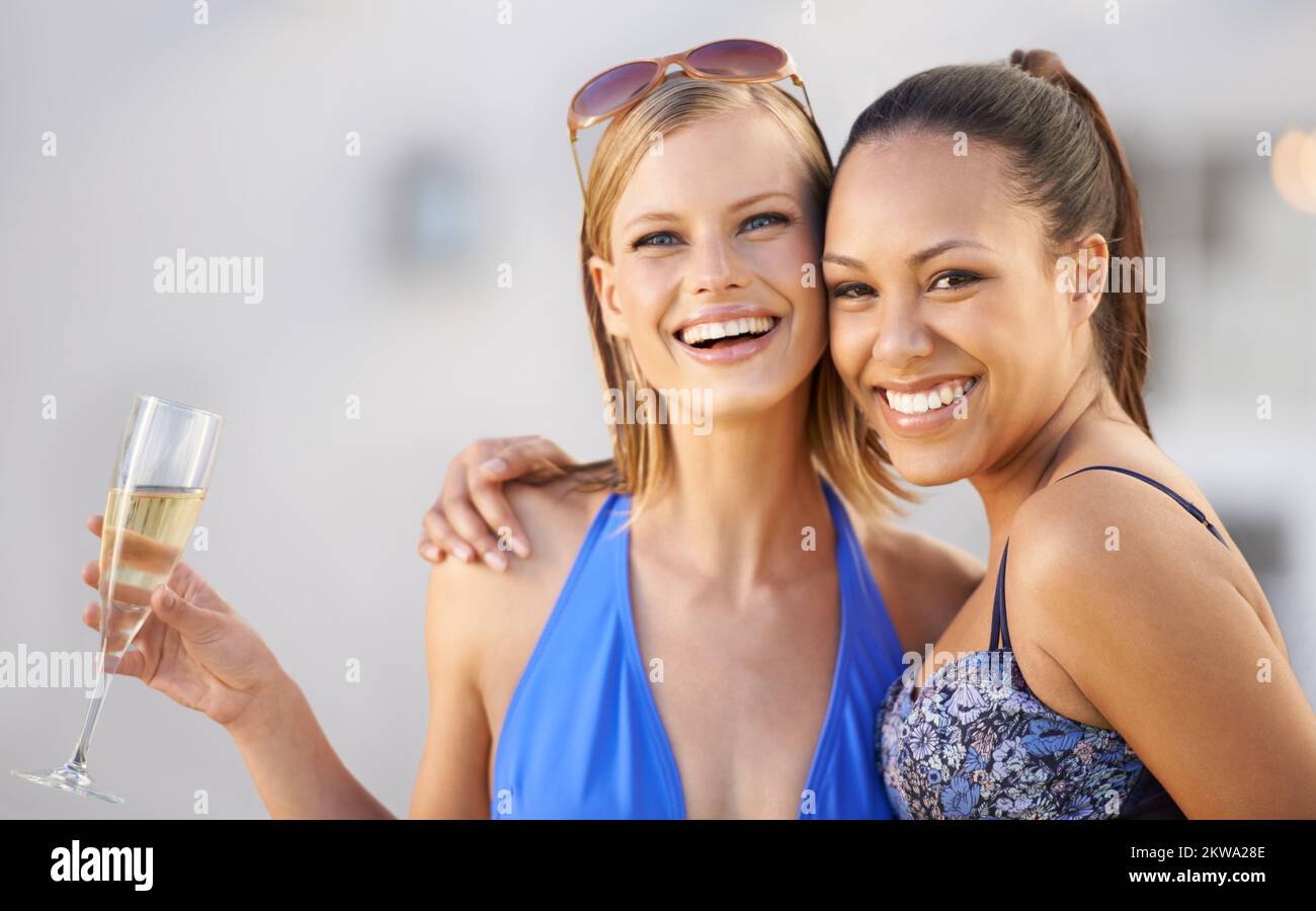 Disfrute de la escapada perfecta sólo para chicas. Dos mujeres jóvenes disfrutando una copa de champán juntas. Foto de stock