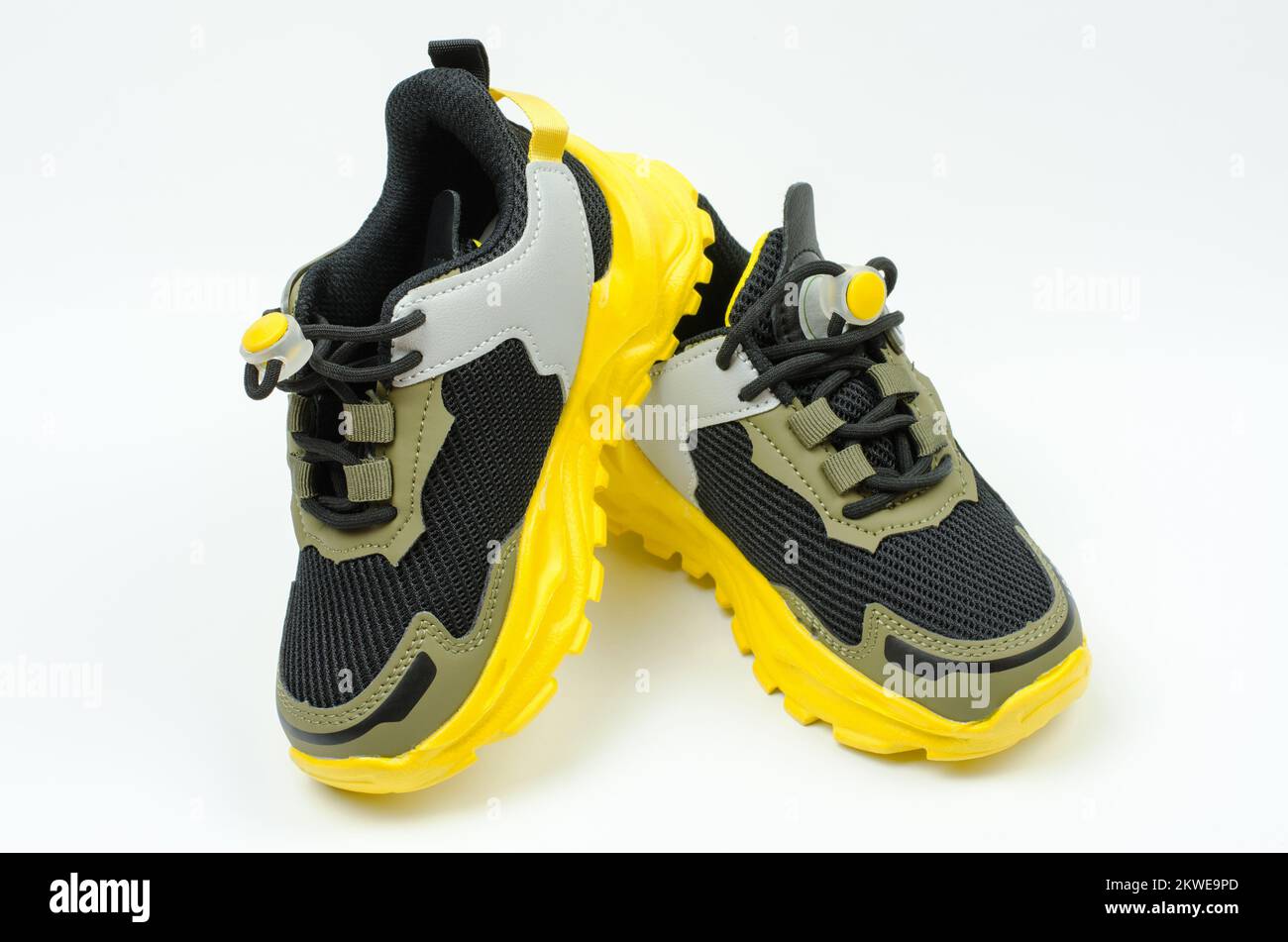 Zapatillas deportivas para niños con suela amarilla sobre fondo blanco.  Zapatillas de lona khaki. Botas deportivas Fotografía de stock - Alamy