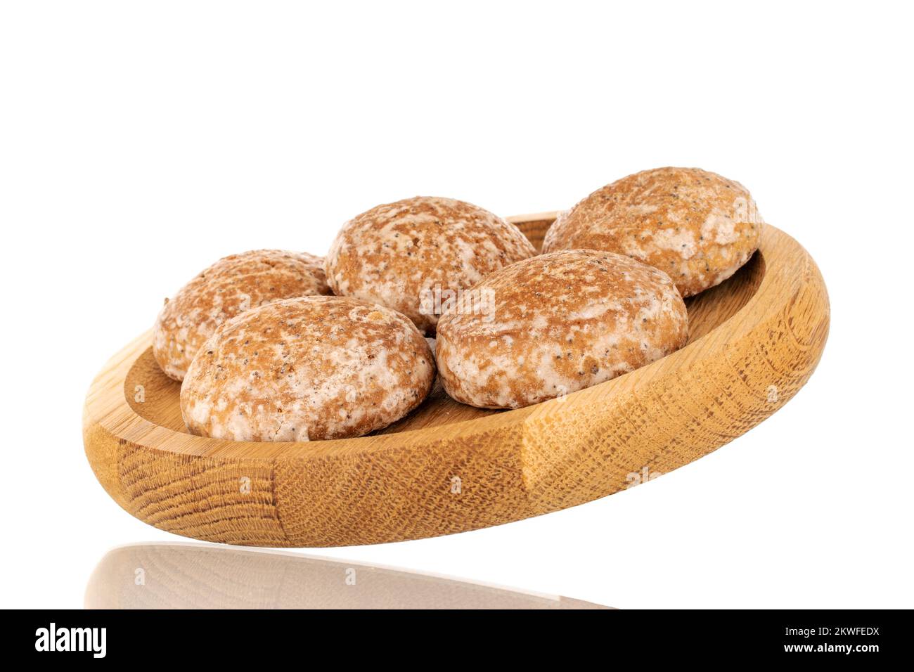 Varias galletas dulces y sabrosas de jengibre sobre un plato de madera, macro, aisladas sobre fondo blanco. Foto de stock