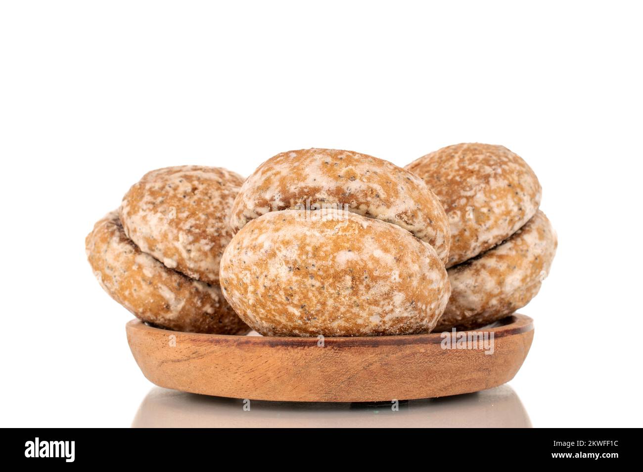 Varias galletas dulces y sabrosas de jengibre sobre un plato de madera, macro, aisladas sobre fondo blanco. Foto de stock