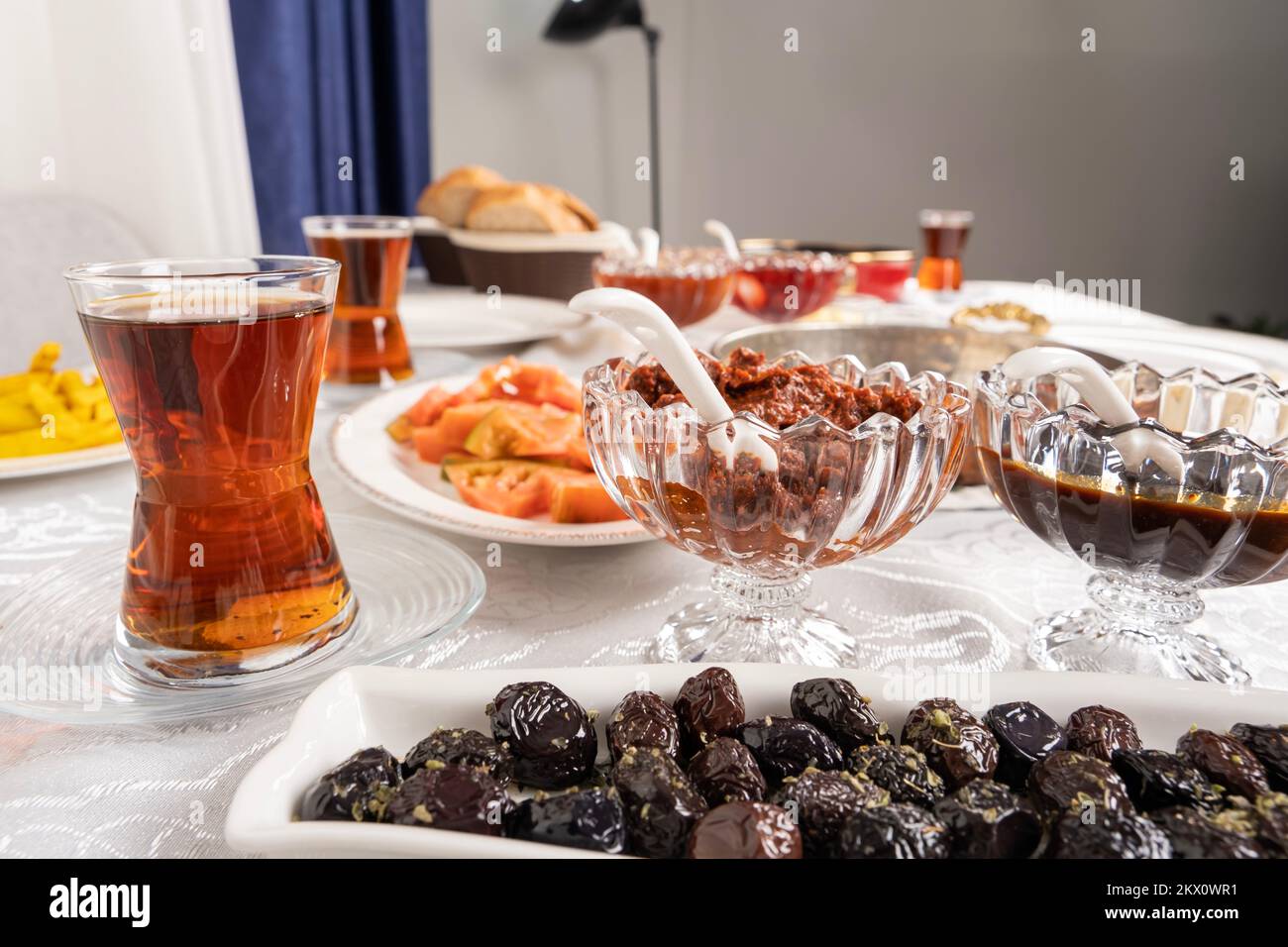 Imagen de cerca de oliva negro. Moderna mesa de desayuno turco. Té en vaso. Rutina matutina familiar. Nadie en la foto, espacio de copia. Foto de stock