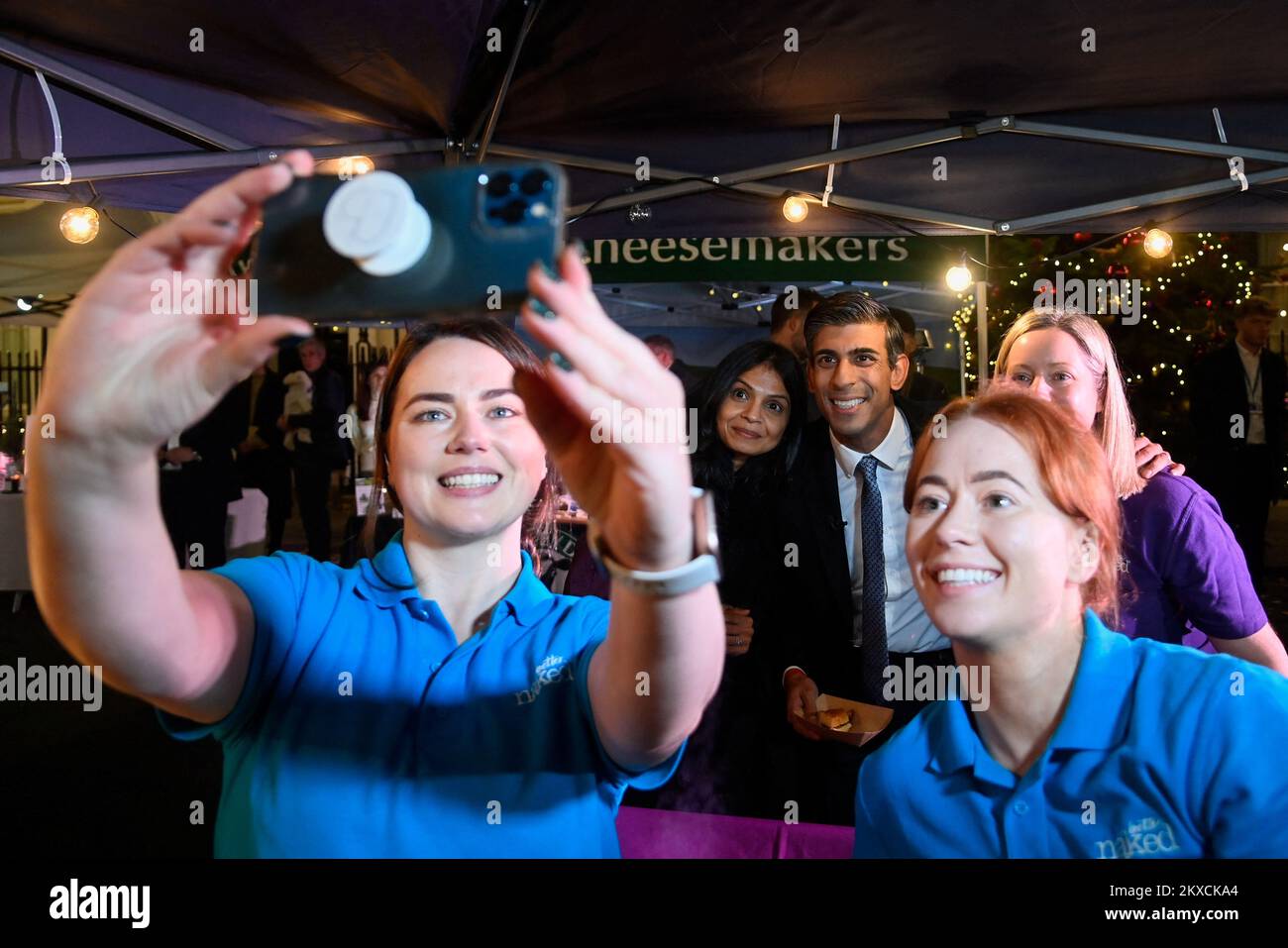 El Primer Ministro Rishi Sunak y su esposa Akshata Murty posan para un selfie mientras visitan un mercado de alimentos y bebidas, mientras Sunak celebra un escaparate festivo en Downing Street, Londres, en forma de mercado callejero para defender empresas de todo el Reino Unido antes del sábado de la pequeña empresa. Fecha de la foto: Miércoles 30 de noviembre de 2022. Foto de stock