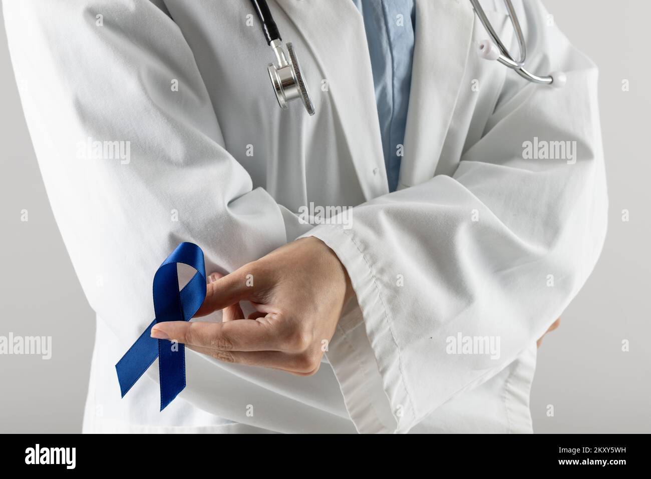 Sección media del doctor caucásico sosteniendo una cinta azul sobre fondo  gris Fotografía de stock - Alamy