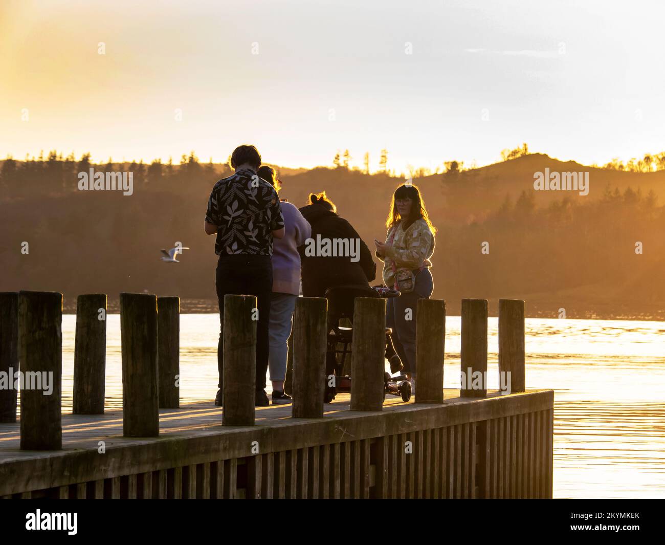 Una familia en un embarcadero en Lake Windermere, Ambleside, Lake District, Reino Unido. Foto de stock