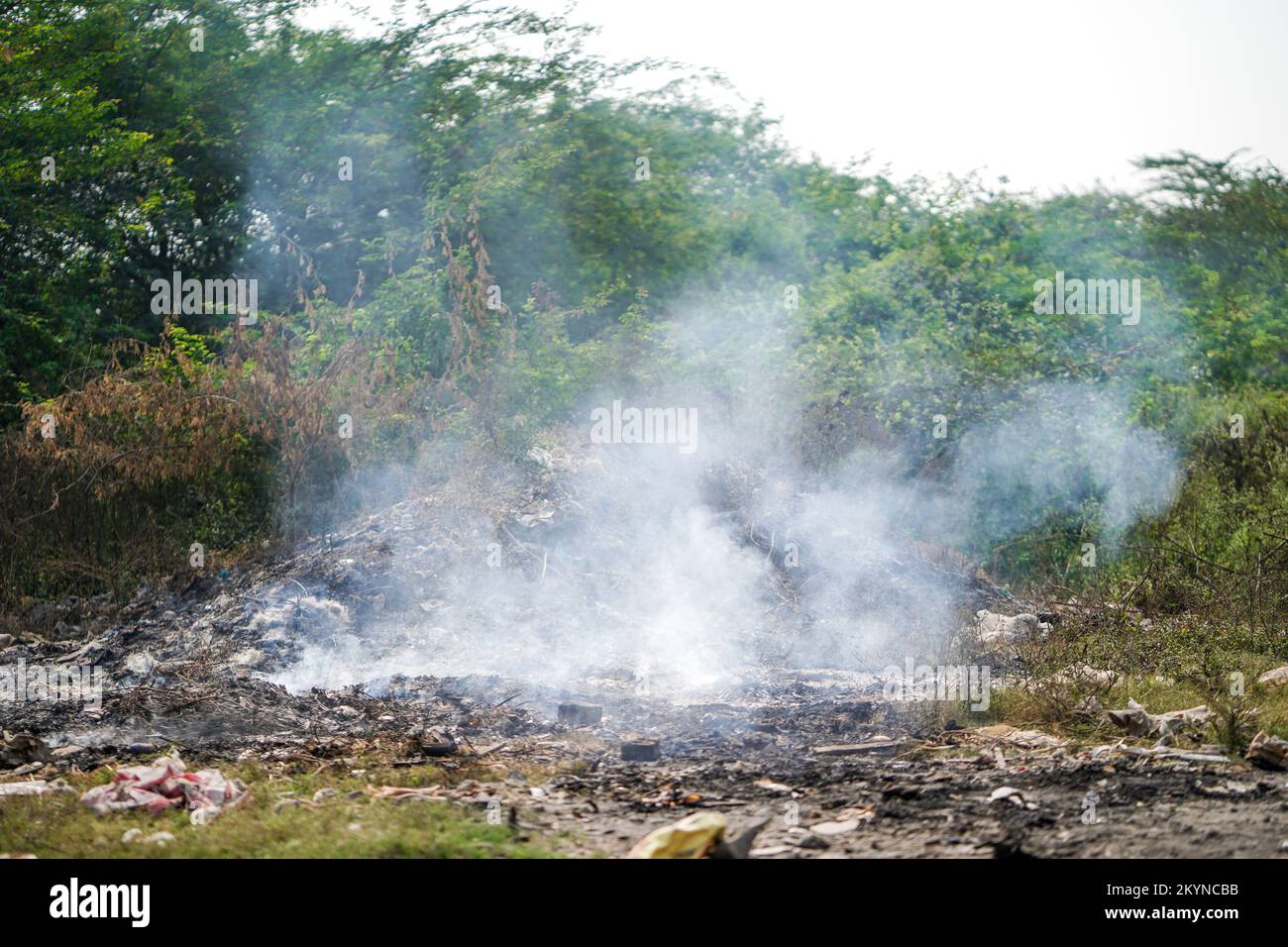 El vertimiento de basura y el sitio ardiente que crea la contaminación del aire por el humo, el día del control de la contaminación, la tierra la contaminación, Raipur, india, Concepto de contaminación Foto de stock