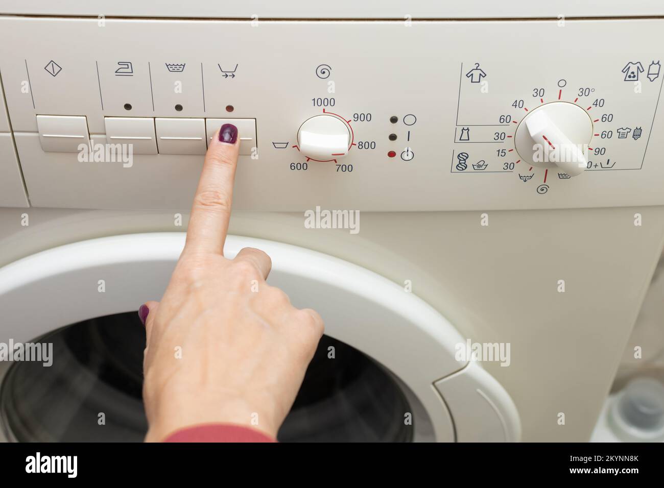 una persona elige un modo de lavado con un interruptor. modo de lavado. modo  de temperatura. lavadora Fotografía de stock - Alamy