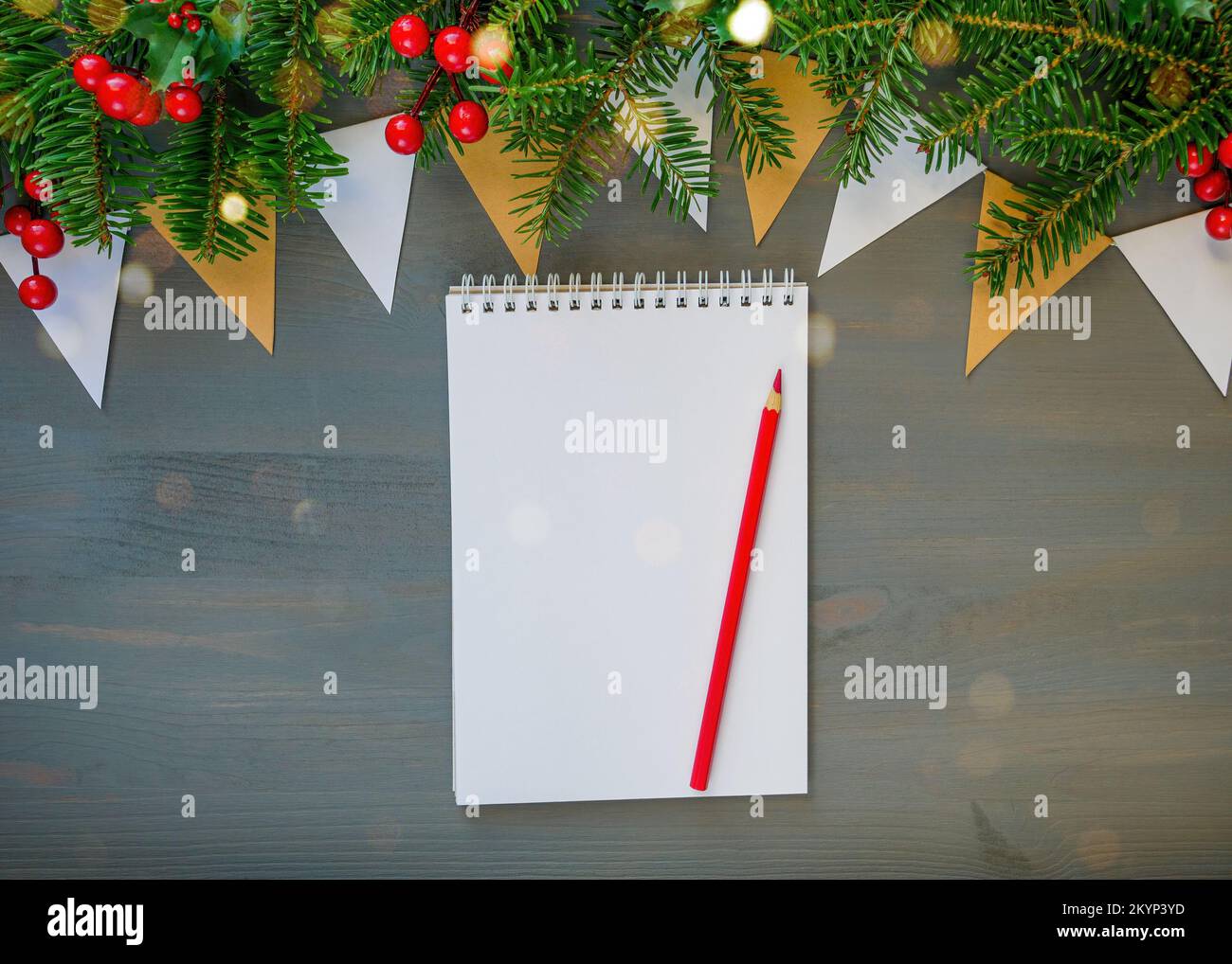 Vista superior de la Navidad con fondo blanco abrir el bloc de notas, lápiz y decoraciones de navidad Foto de stock