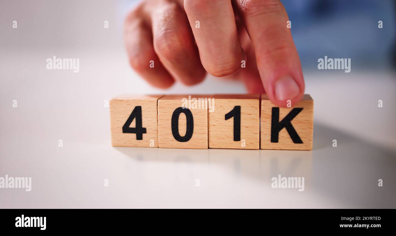 Una persona recogiendo K Alfabeto de 401k Plan de Pensiones junto a alcancía Foto de stock