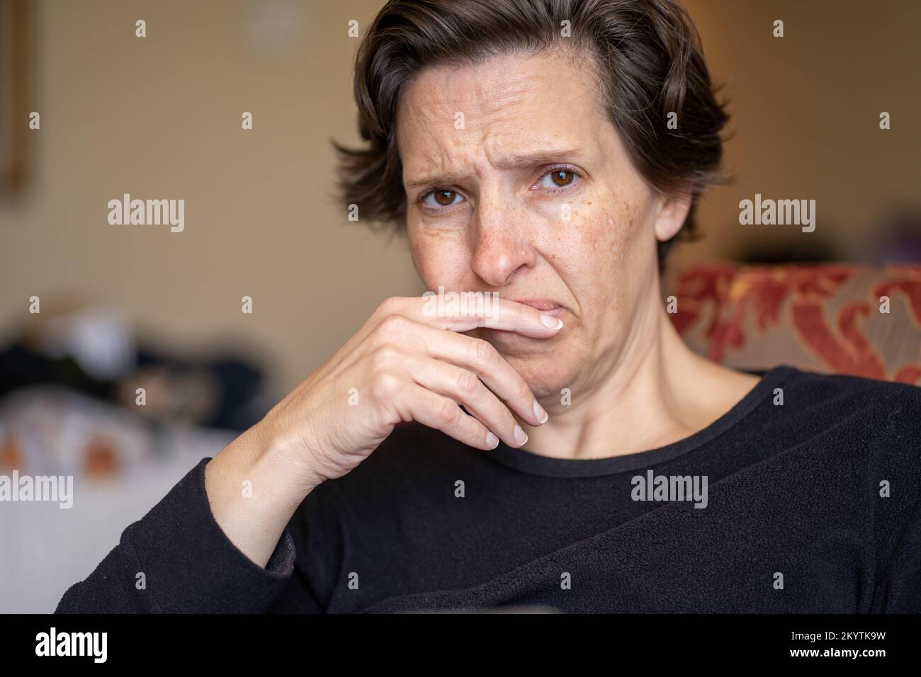 Mujer pensiva en sus 50s mirando la cámara Foto de stock