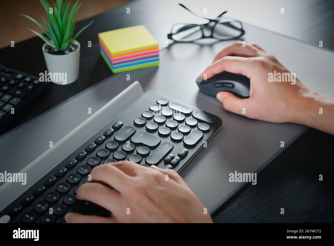 Hombre usando el ratón de ordenador. Trabajar en la oficina Foto de stock