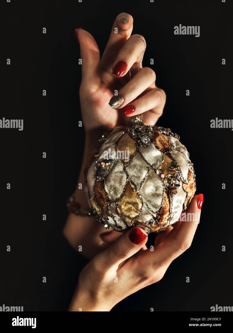 De cerca las manos de la mujer con manicura celebración bola de Navidad Foto de stock