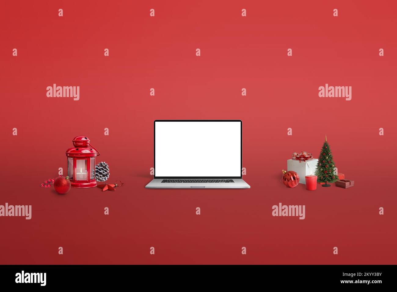 Maqueta de portátil sobre fondo rojo rodeada de decoraciones navideñas Foto de stock