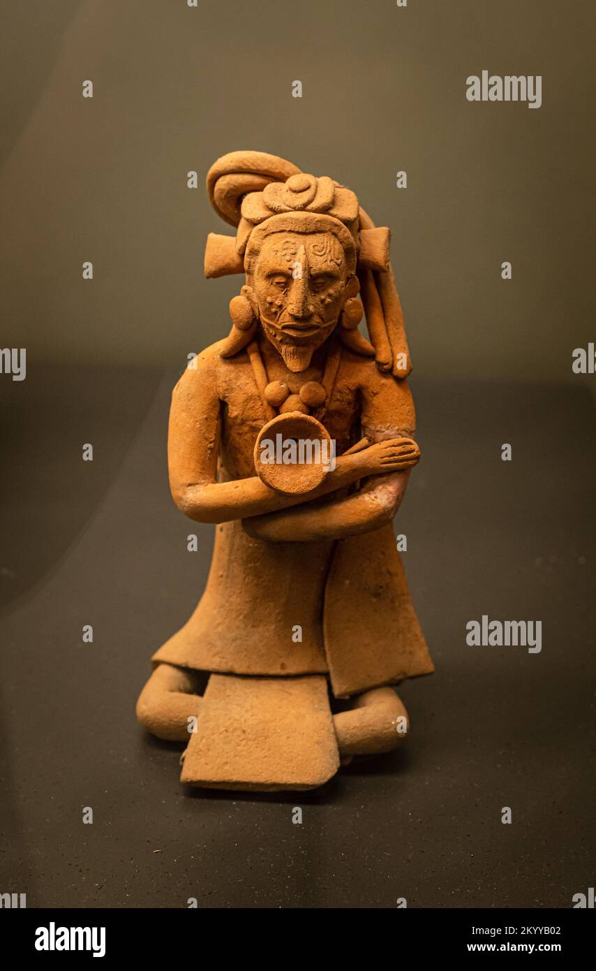 Figura de cerámica maya que representa a un hombre con el pelo largo, atado y escarificación en su cara. Late Classic, Campeche, México. Foto de stock