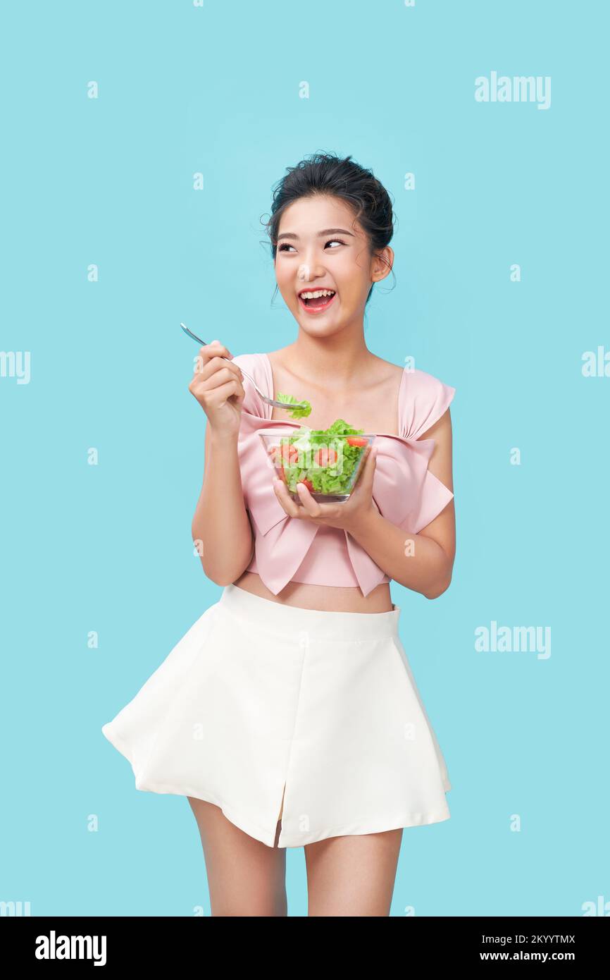 Alegre niña asiática comiendo alimentos saludables de fondo Foto de stock