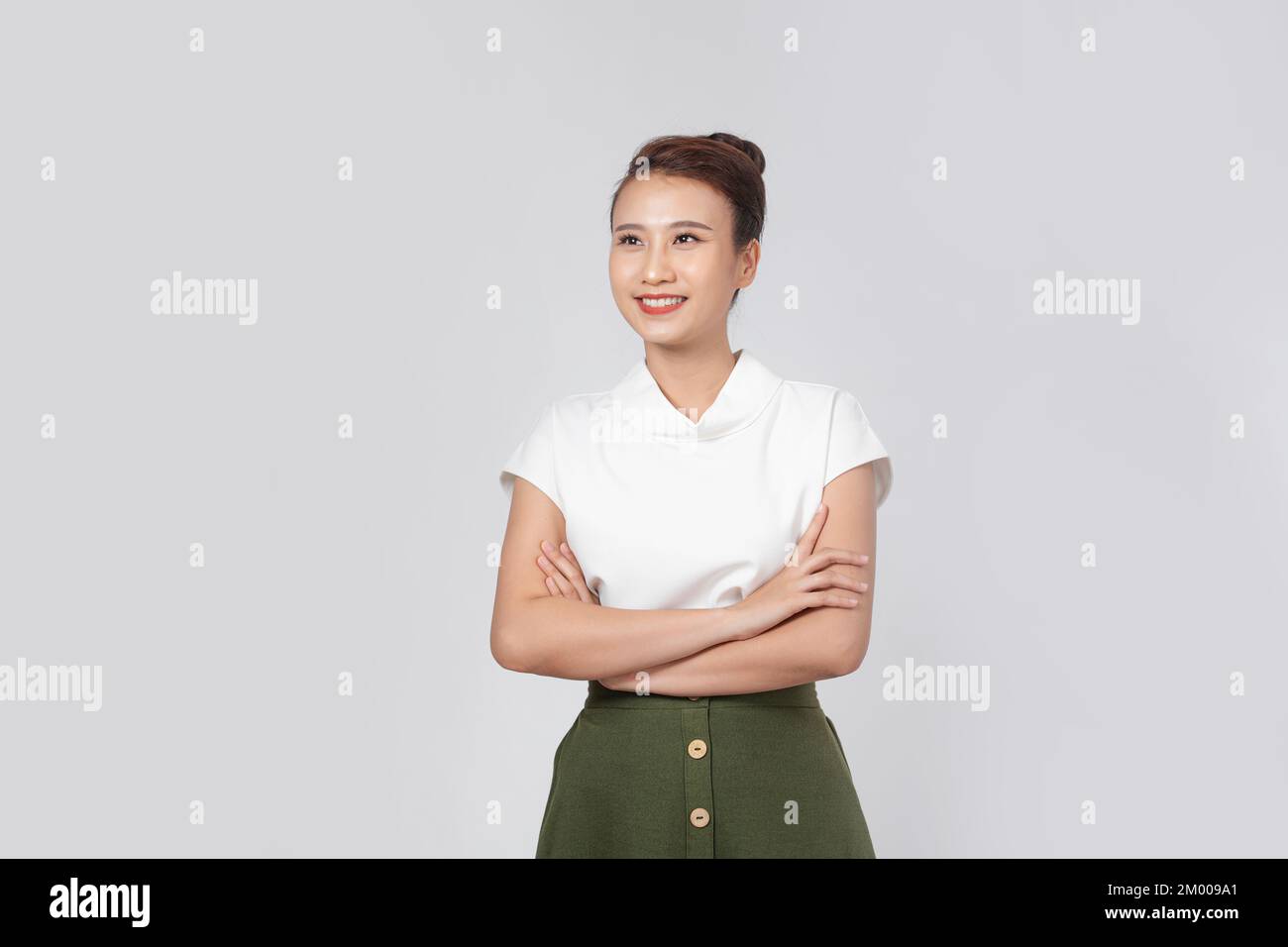 Retrato sonriente joven asiática con brazos cruzados Foto de stock