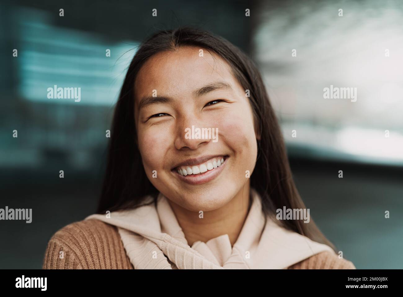 Feliz chica asiática posando y sonriendo delante de la cámara Foto de stock