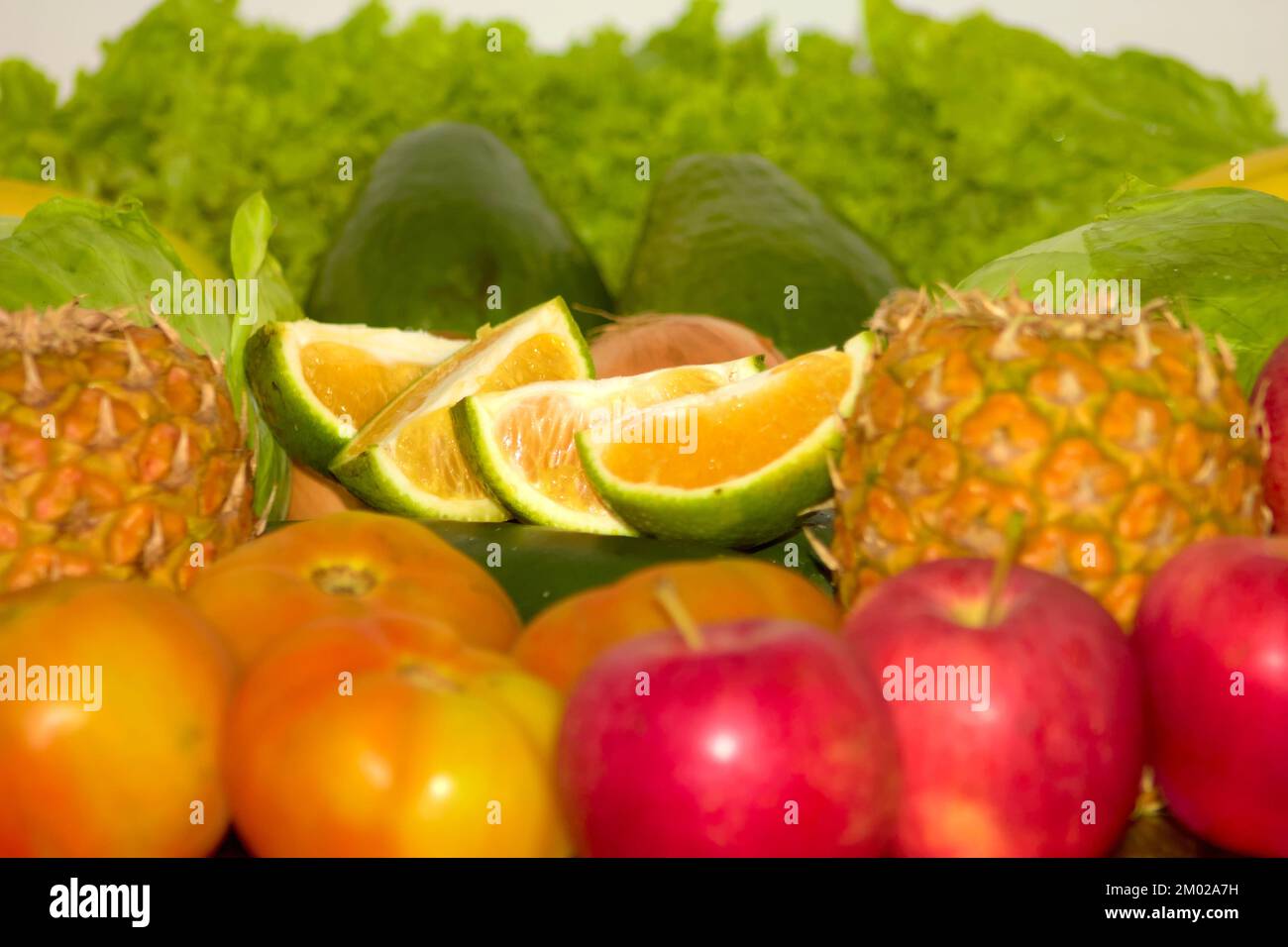 Variedad de frutas y verduras agrupadas como plátano, pepino, manzana, piña, lechuga, tomate, naranja y más Foto de stock