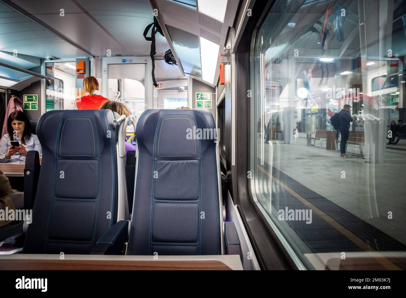 Imagen de un asiento típico de un tren europeo, vacío, en ruta en una estación de tren típica de Europa, en un moderno tren regional de la UEM. Foto de stock