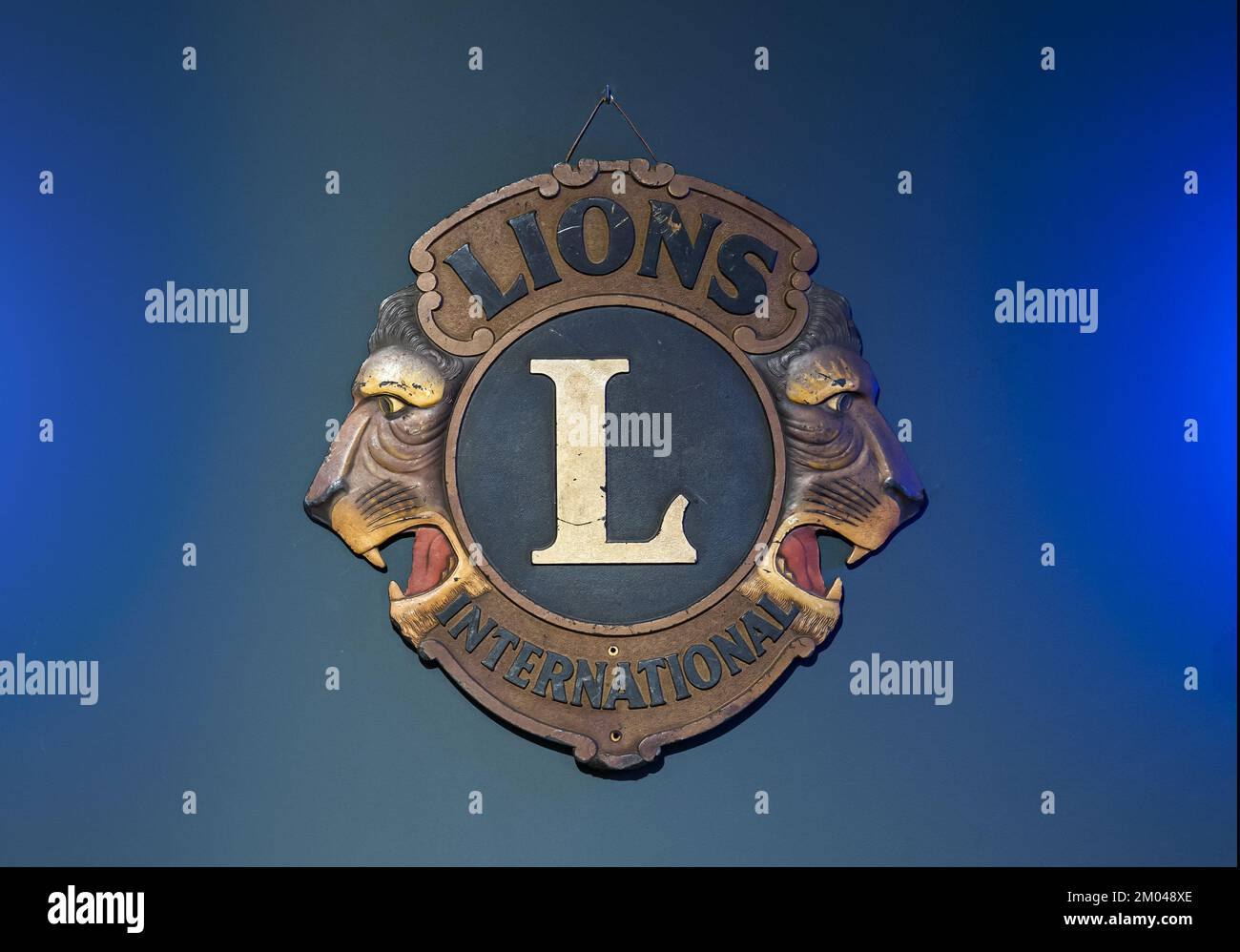 Insignia retro con emblema para el club Lions International sobre fondo azul brillante Foto de stock