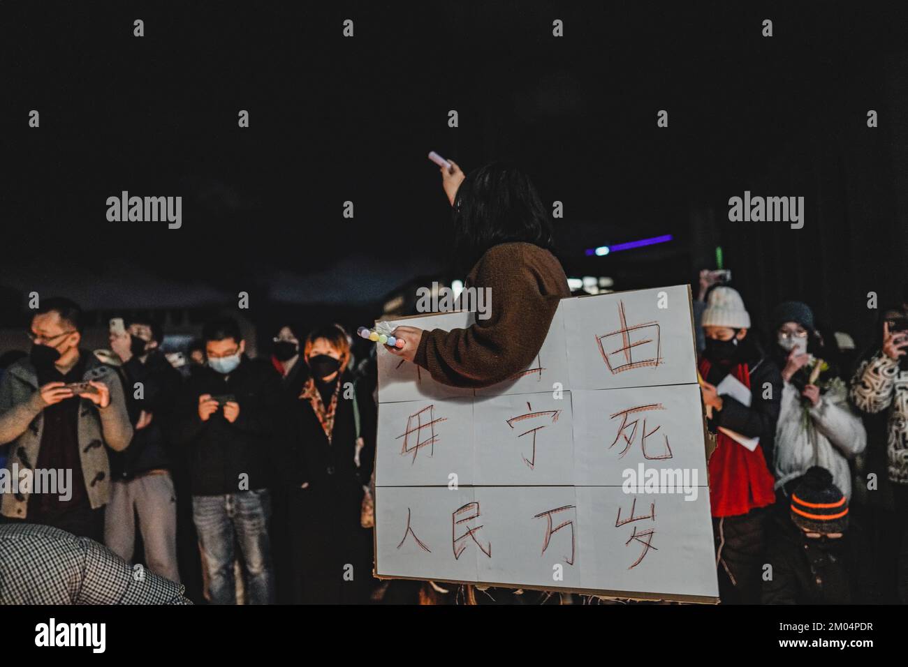 Un manifestante sostiene un cartel que dice 'Dame la libertad, o dame la muerte' durante la manifestación. En la Universidad de Washington, más de doscientas personas se reunieron para mostrar su solidaridad con la protesta del «libro blanco» en China. Los manifestantes pidieron al gobierno chino que liberara a todos los manifestantes, liberara a China y le pidiera al presidente Xi que dimitiera. Sin embargo, los manifestantes encendieron una vela para simbolizar una tragedia bajo control excesivo para mostrar su apoyo a la tragedia del fuego de Urumqi. Esta tragedia cobró la vida de diez personas y dejó heridas a otras nueve. (Foto de Chin Hei Leung/SOPA Images/Sipa Foto de stock