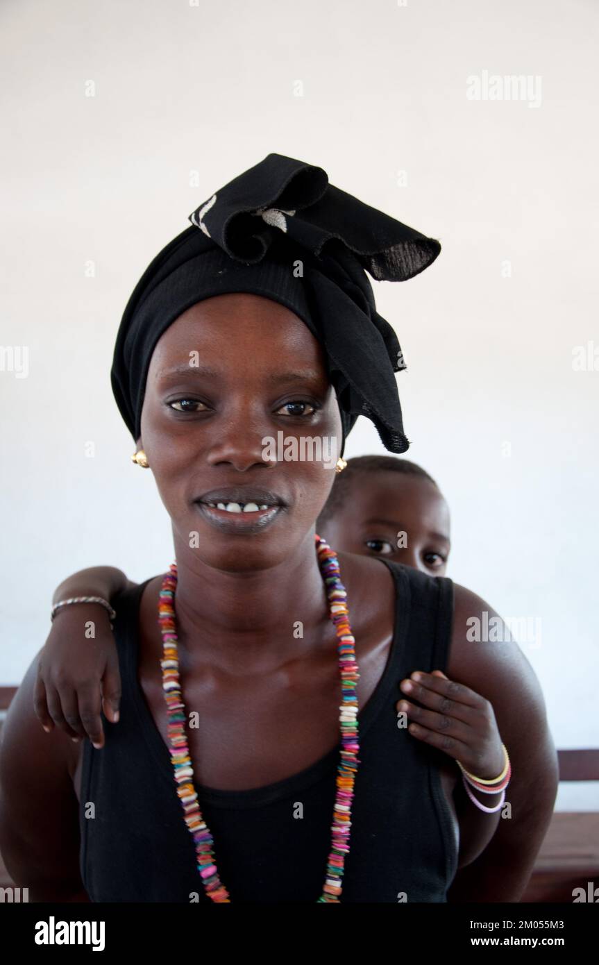 Caras de África, mujer africana con bebé en la espalda, Bafata, Guinea Bissau Foto de stock