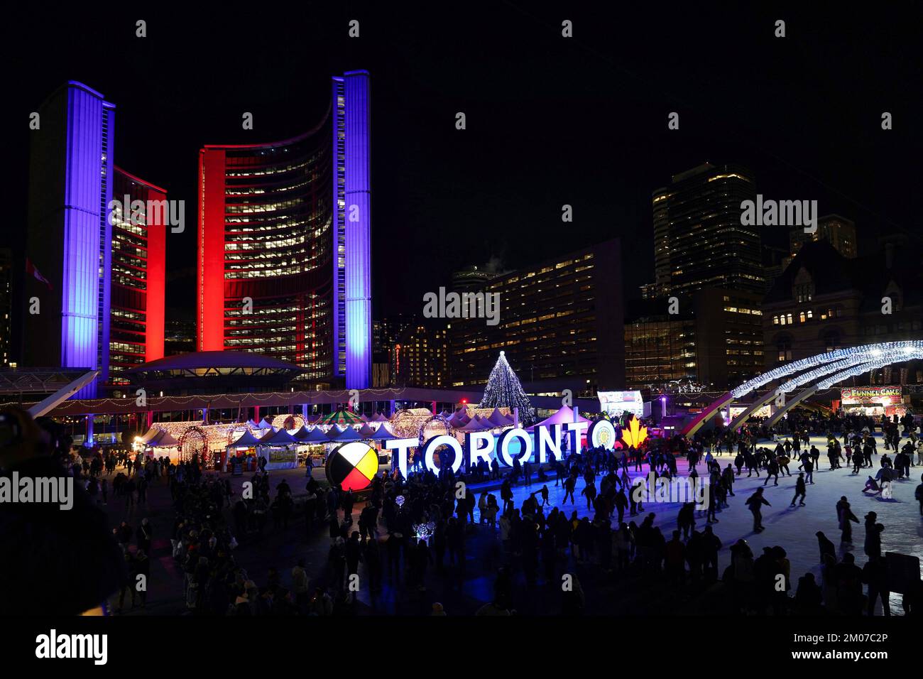 Toronto, Canadá - 4 de diciembre de 2022: Cada año Toronto llena la plaza frente al Ayuntamiento con un carnaval de Navidad con luces, atracciones y vendedor Foto de stock