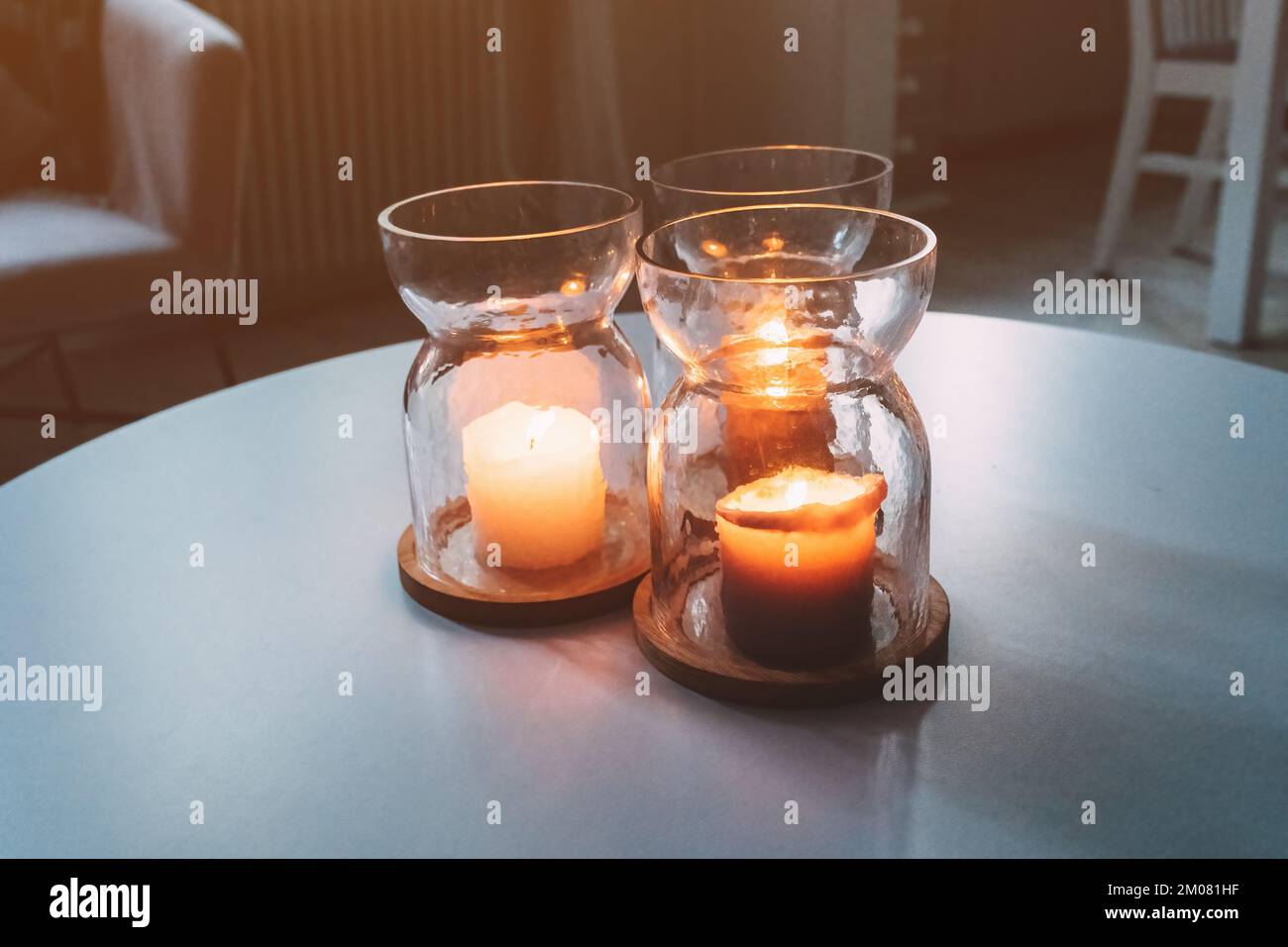 Tres velas en tarros en la mesa del salón, enfoque selectivo Foto de stock